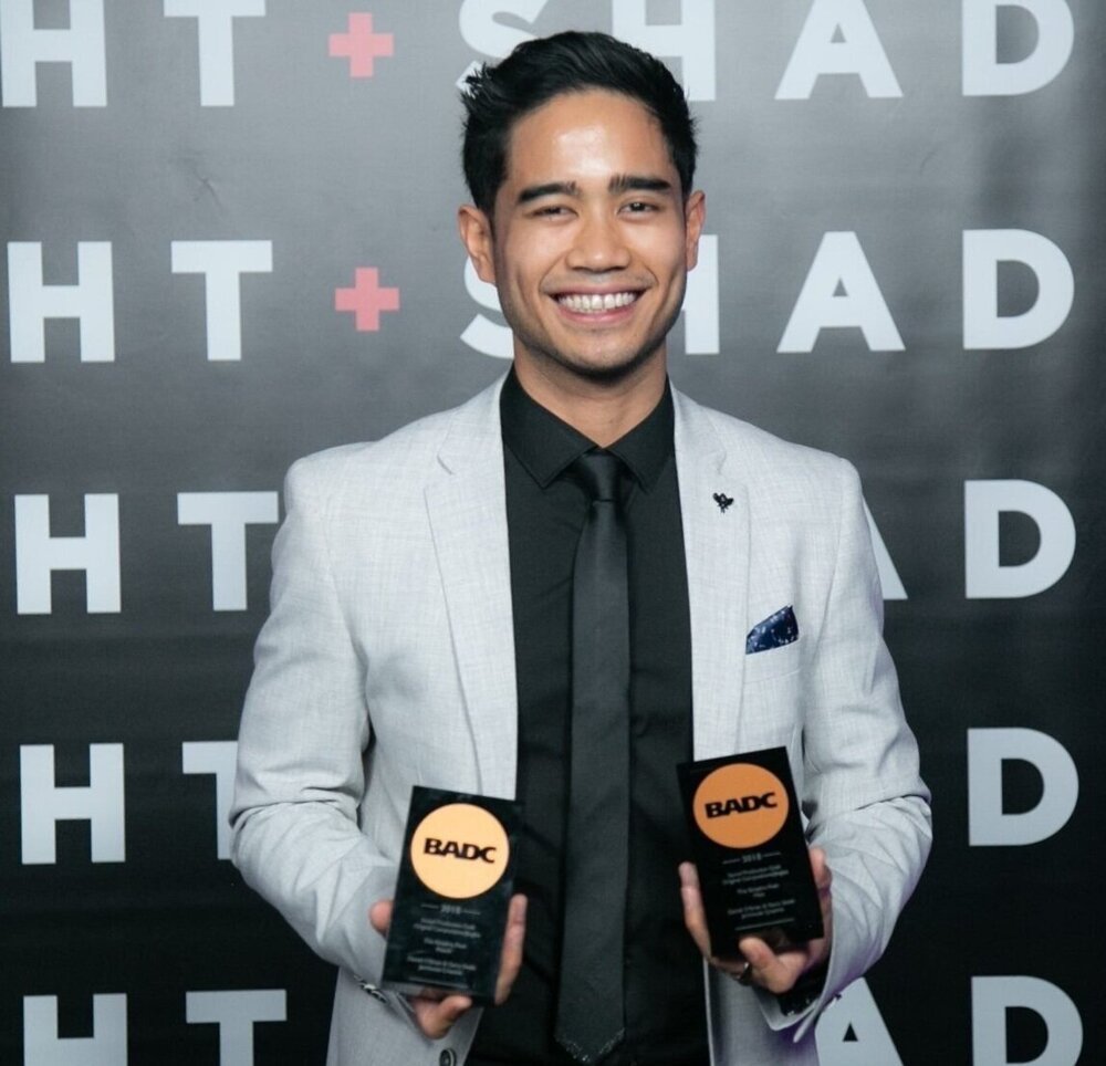 Daniel O’Brien smiling and holding two BADC awards at the event