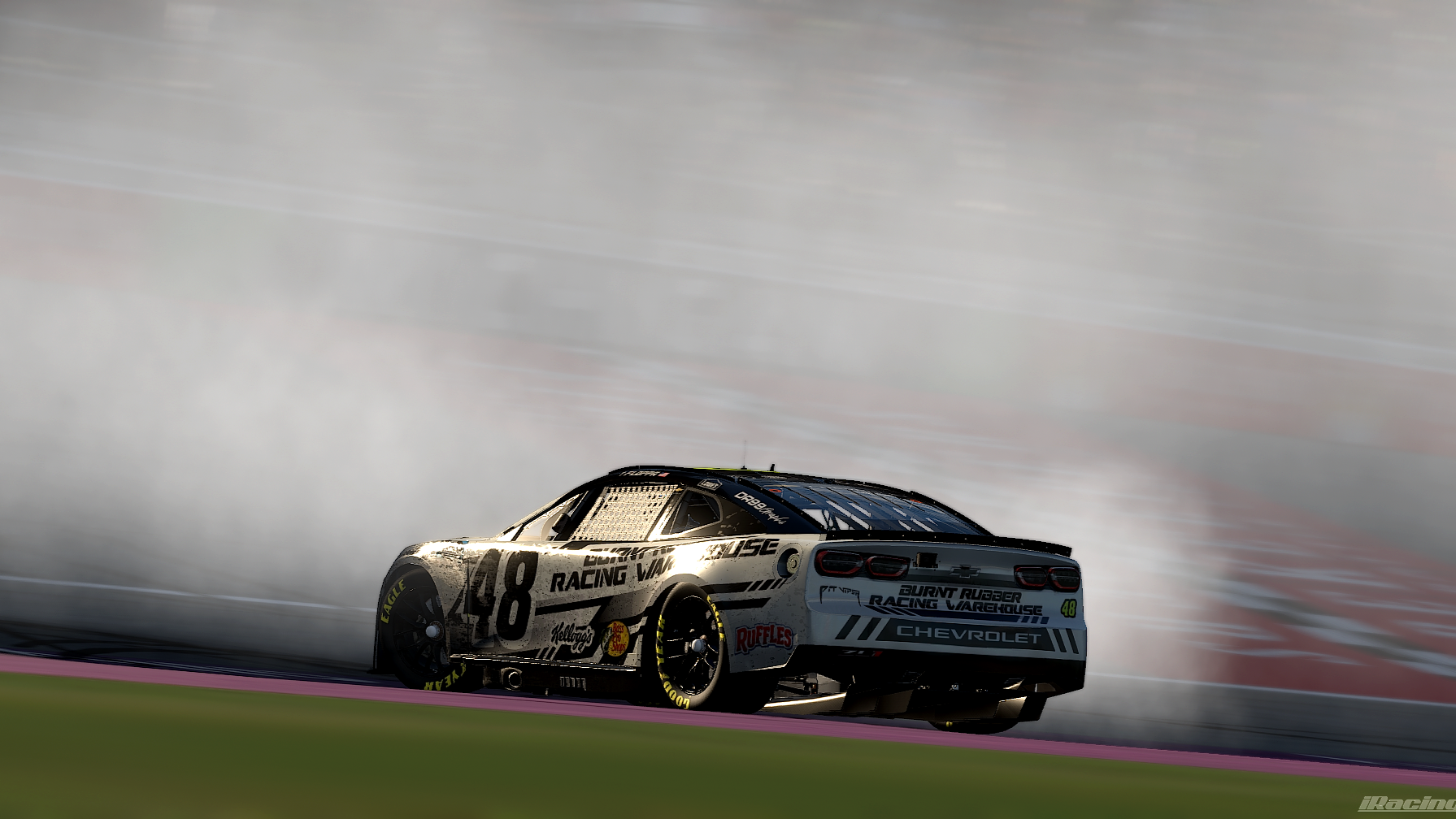 A race car speeding on a track, kicking up dust or smoke behind it. The car is white with black and yellow accents, featuring decals and sponsorship logos, including Chevrolet and Kellogg's.