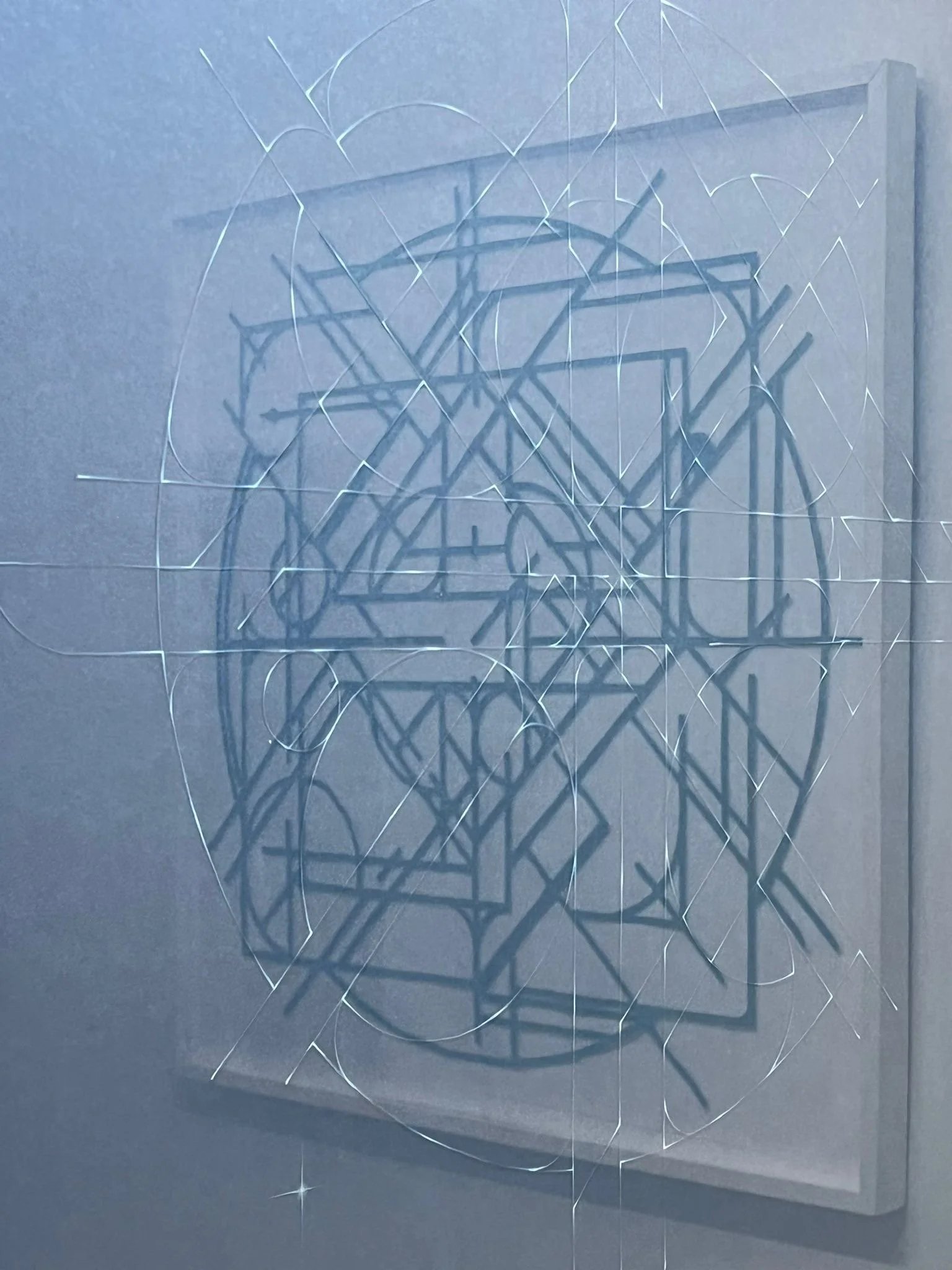 abstract geometric artwork reflected in second similar artwork glass