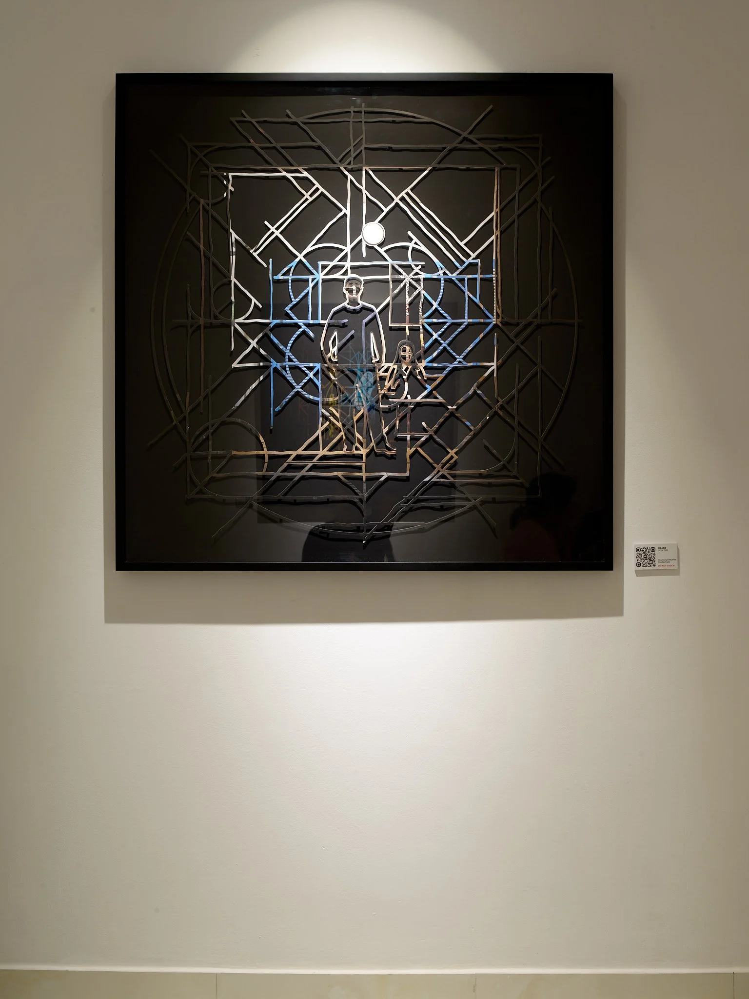 abstract geometric mandala  with central figure framed on gallery wall