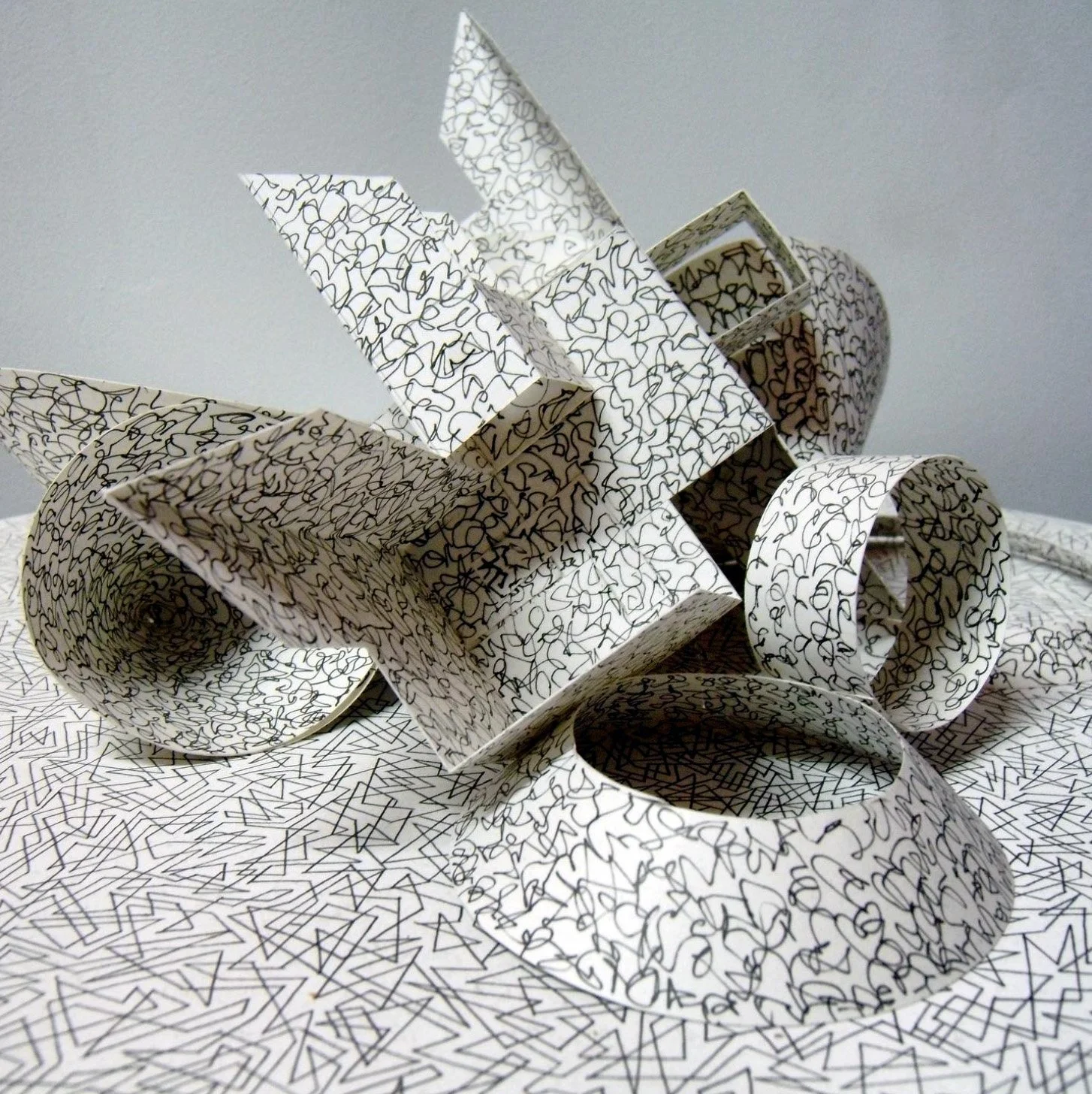abstract white paper sculpture covered with intricate black line drawings on its surface