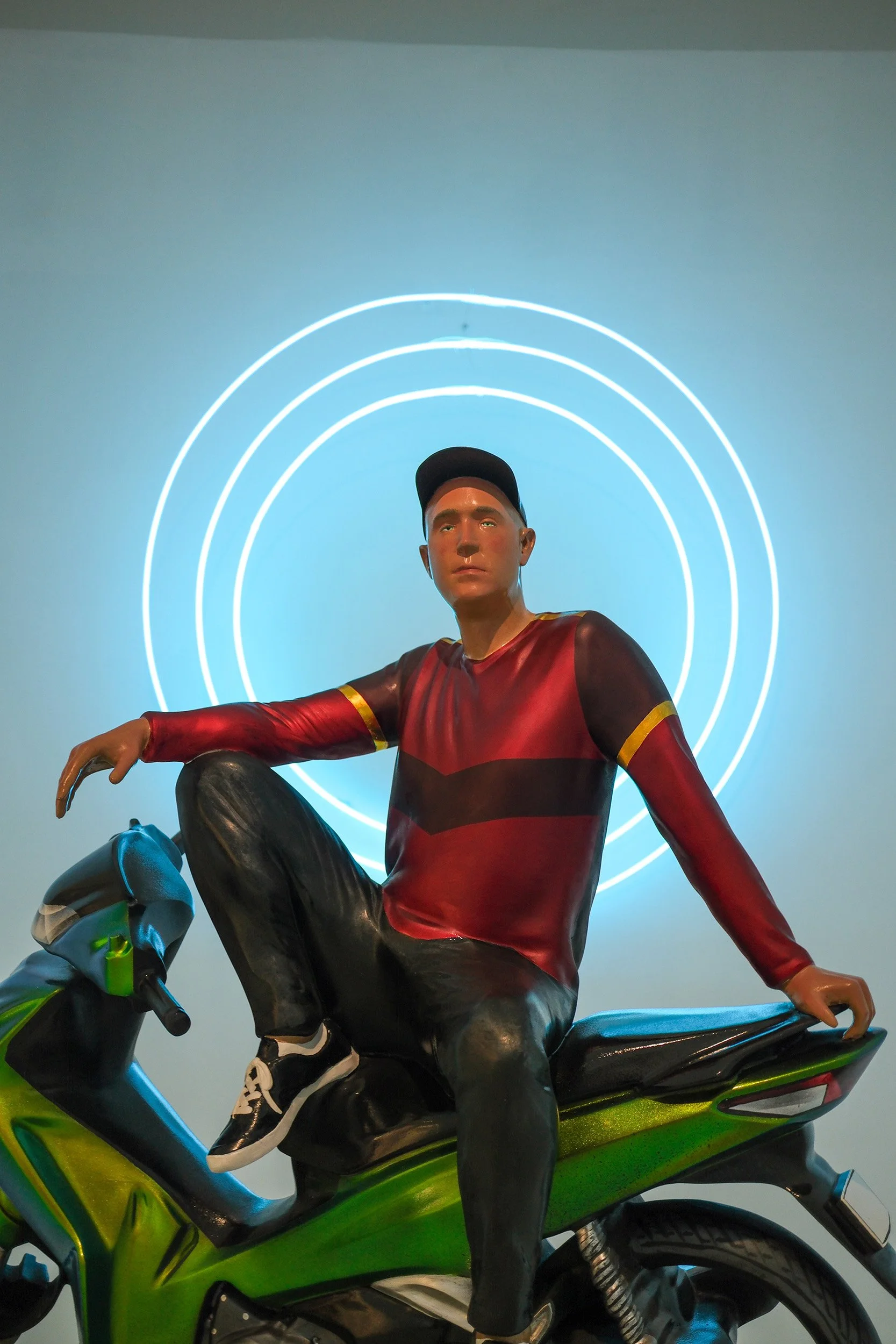 sculpture of man sitting on a motorbike like a bodhisattva