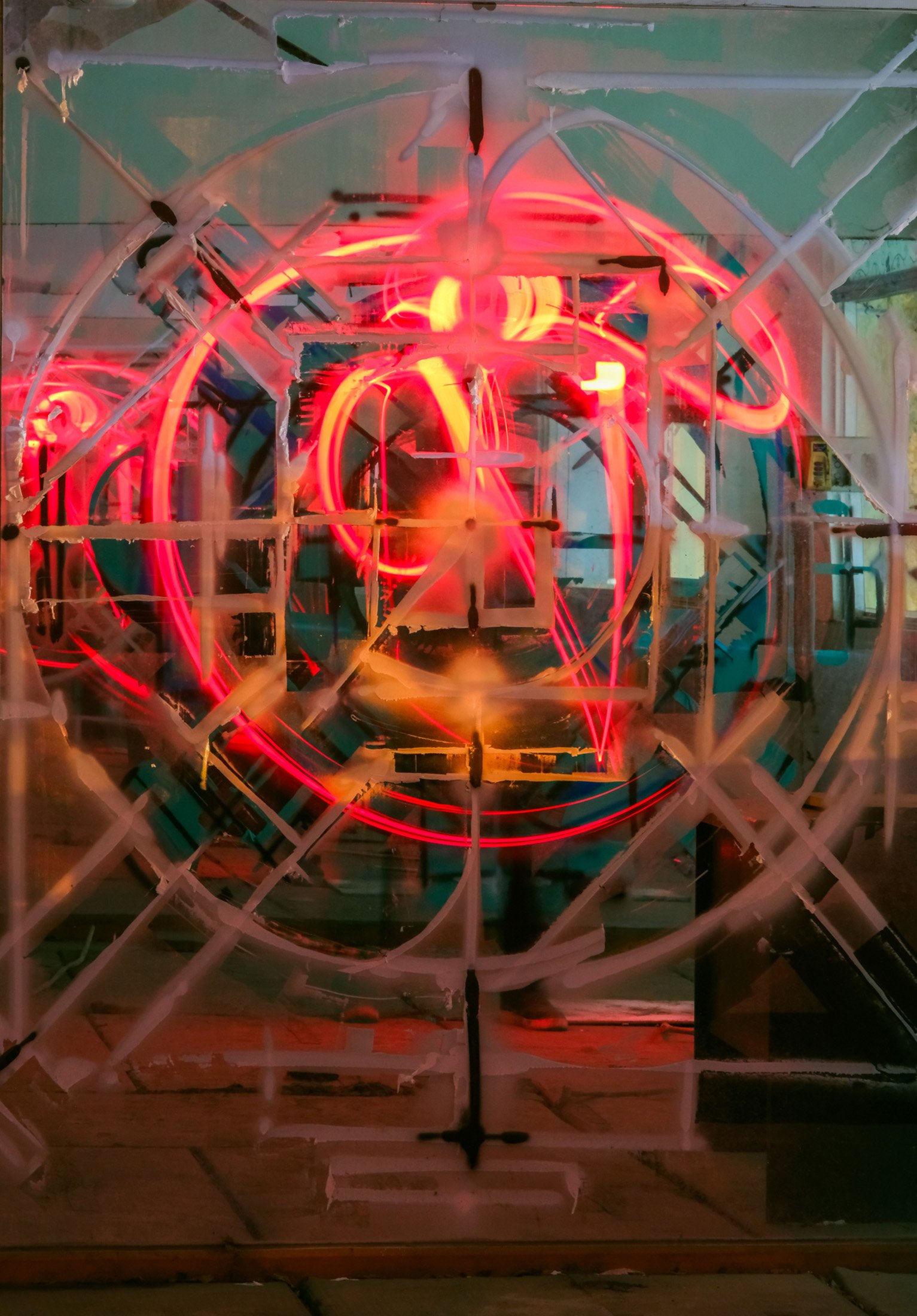 an abstract geometric mandala with spray paint on a mirror in an abandoned room with some lines drawn in the reflection with light