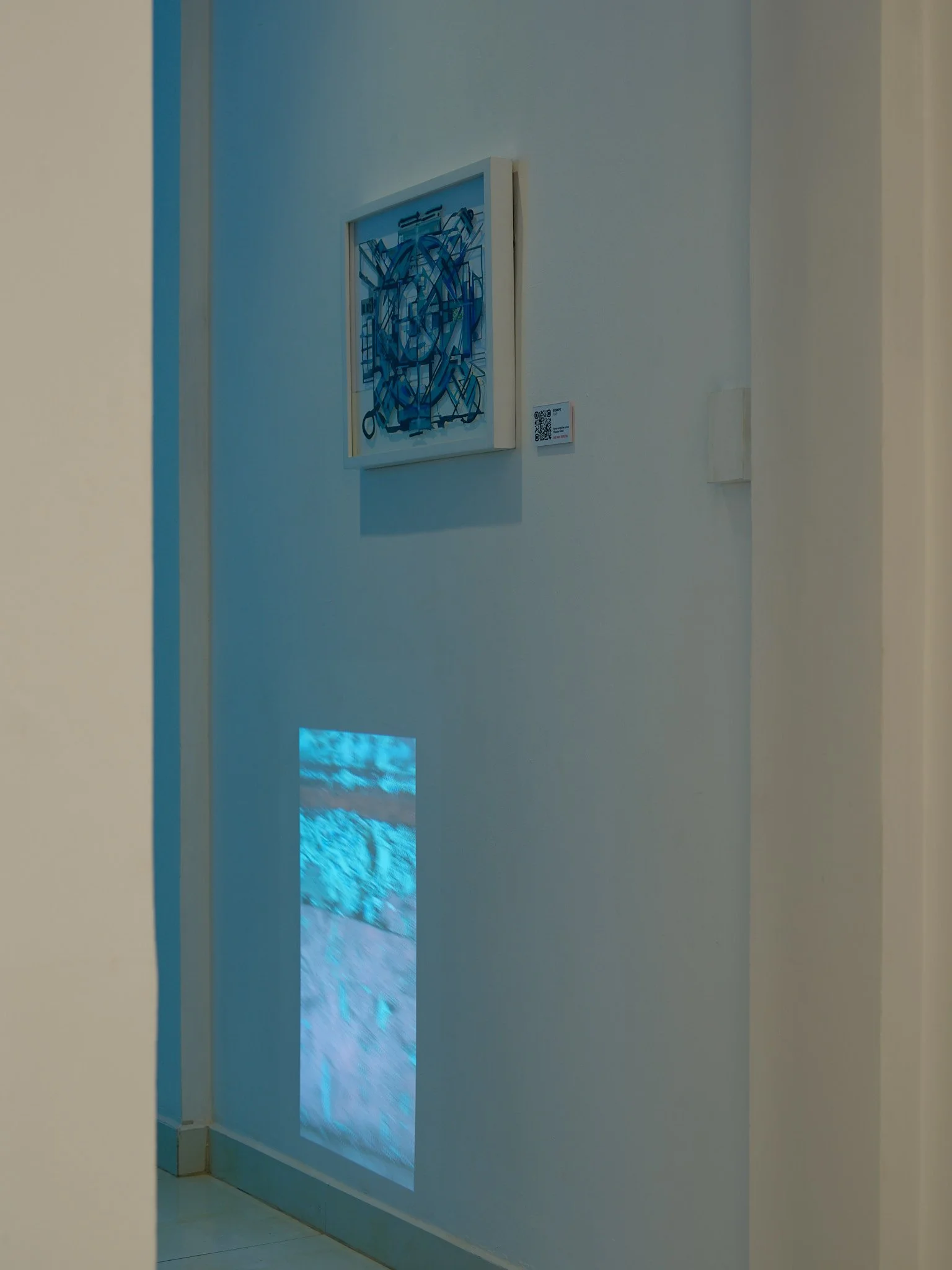 abstract geometric mandala framed on gallery wall with video projected on the wall below