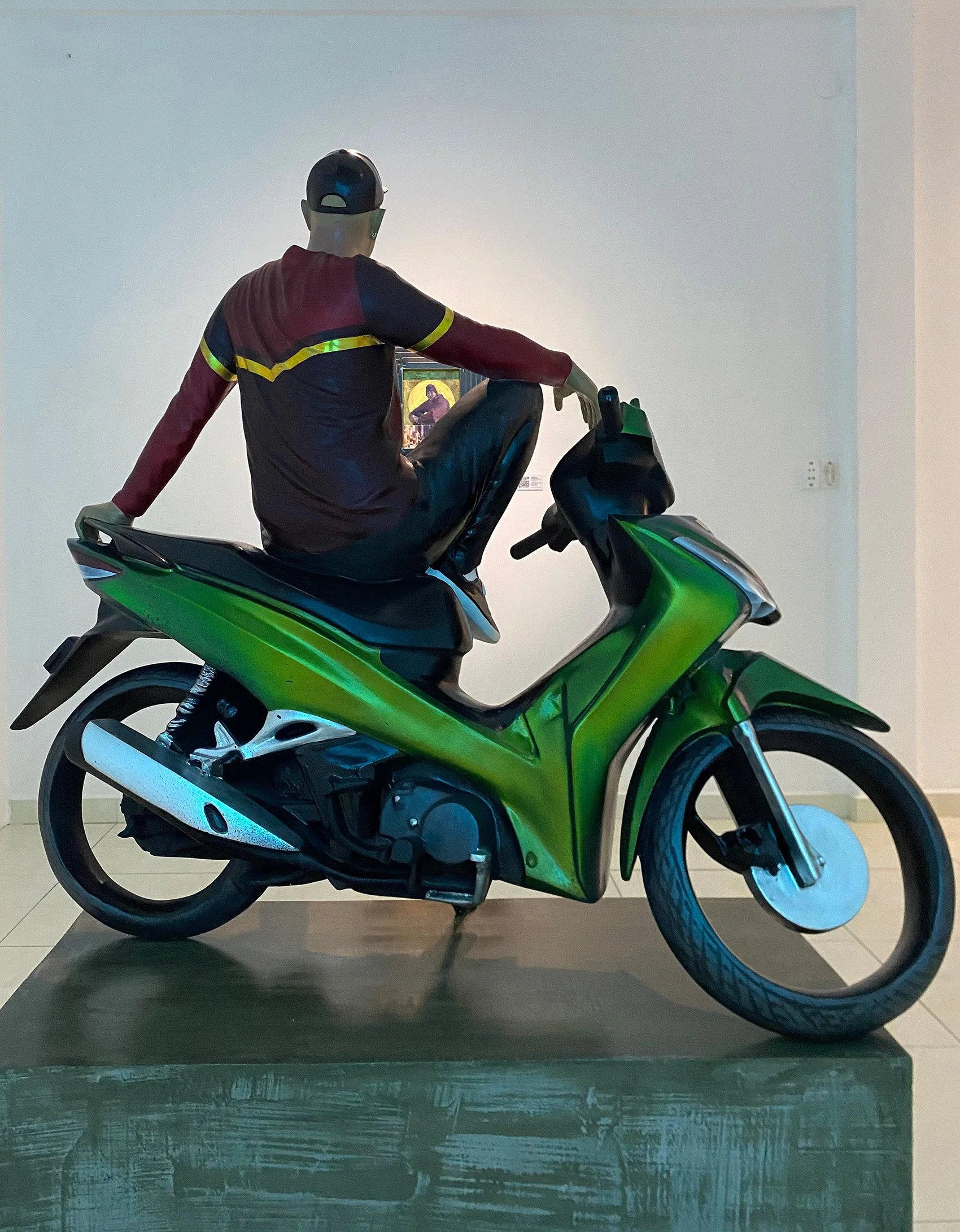 sculpture of man sitting on a motorbike like a bodhisattva
