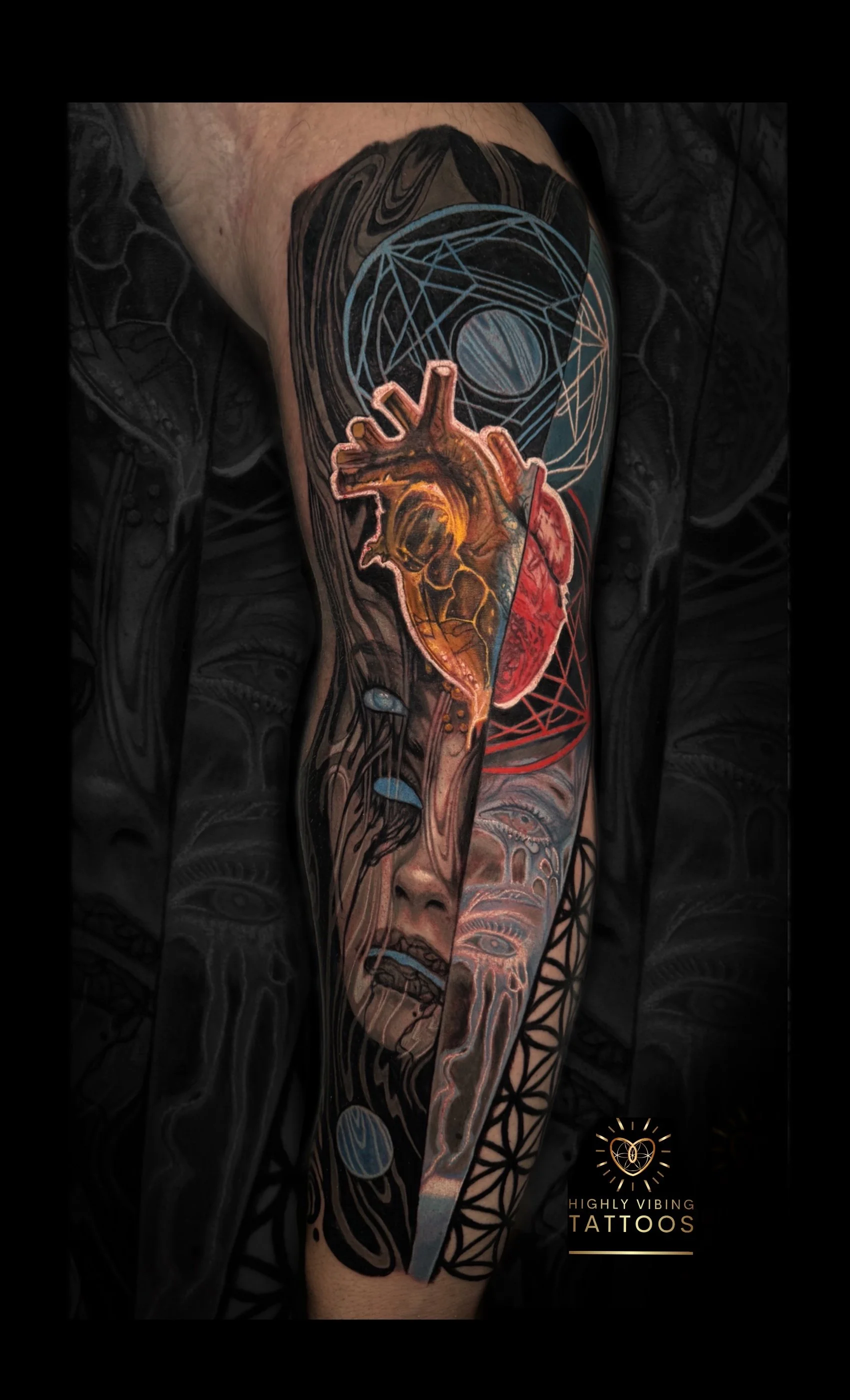 Colorful tattoo on person's arm featuring an anatomical heart, geometric patterns, faces, eyes, and abstract designs. Daniel Armitage, Calgary Alberta, Surrealist Tattoo Artist, YYC