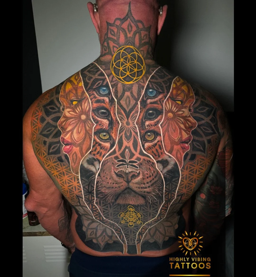 Colorful full-back tattoo featuring a lion's face merged with other animal faces and human profiles, along with geometric and floral patterns.