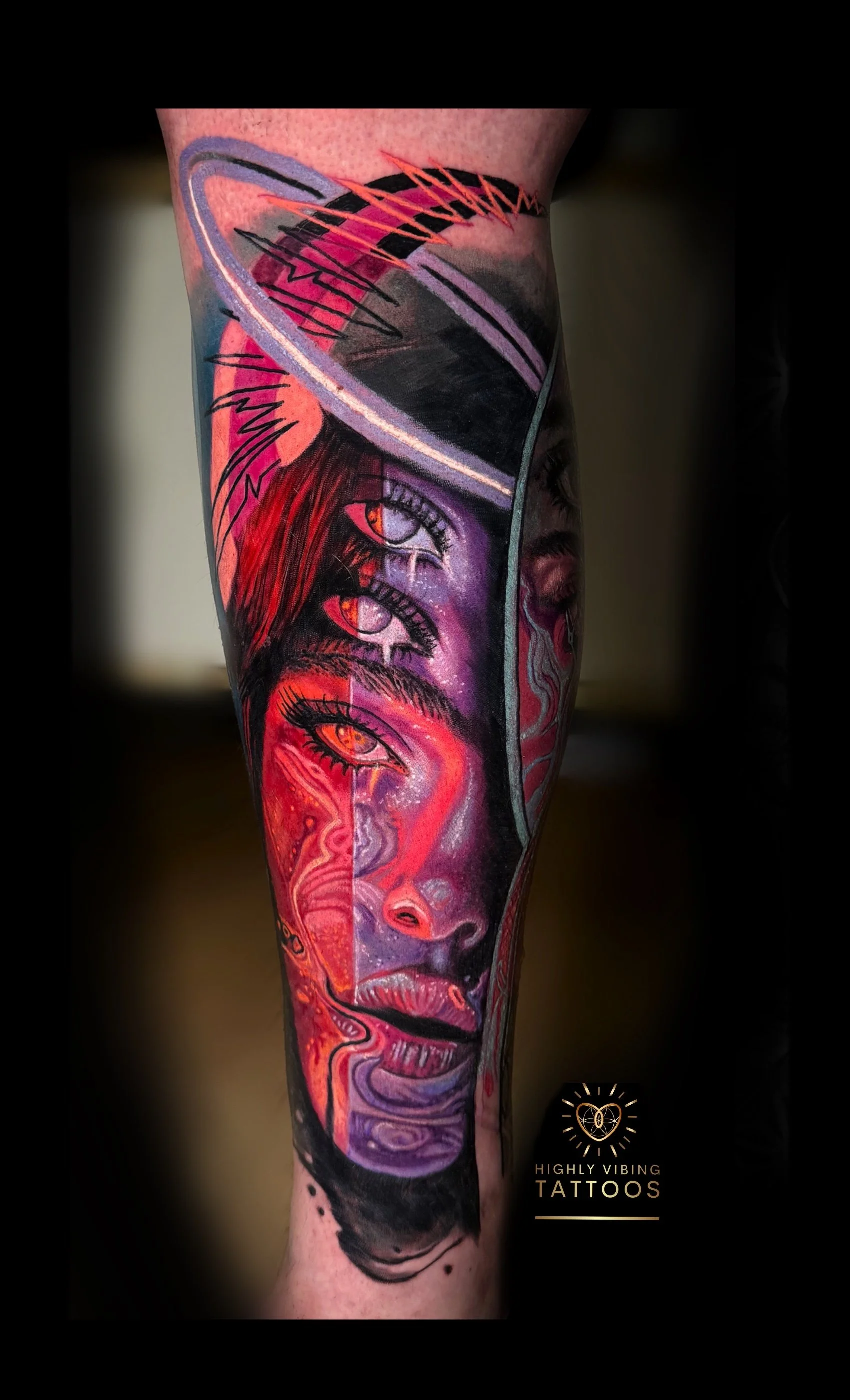 Colorful tattoo sleeve featuring a surreal portrait of a woman with multiple eyes on her face, vibrant red and purple hues, and abstract elements. Daniel Armitage, Calgary Alberta, Surrealist Tattoo Artist, YYC