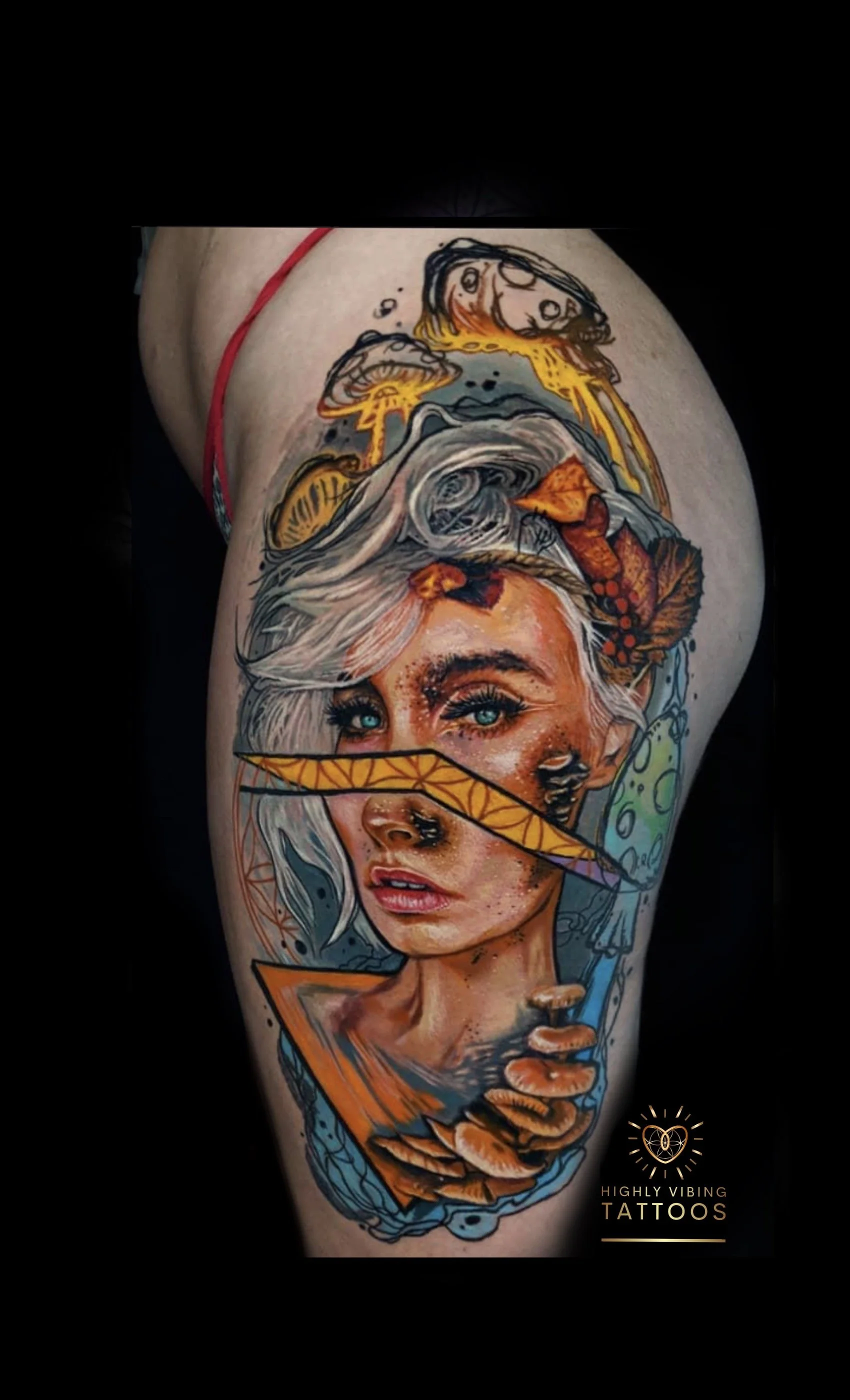 Colorful tattoo of a woman's face with blue eyes, white hair, and a dreamy expression, incorporating mushrooms, autumn leaves, and geometric shapes. Daniel Armitage, Calgary Alberta, Surrealist Tattoo Artist, YYC