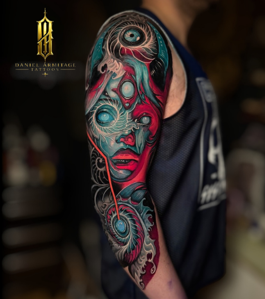 Daniel Armitage, Calgary Alberta, Surrealist Tattoo Artist, YYC Colorful tattoo of a woman's face with abstract and surreal elements on the upper arm.