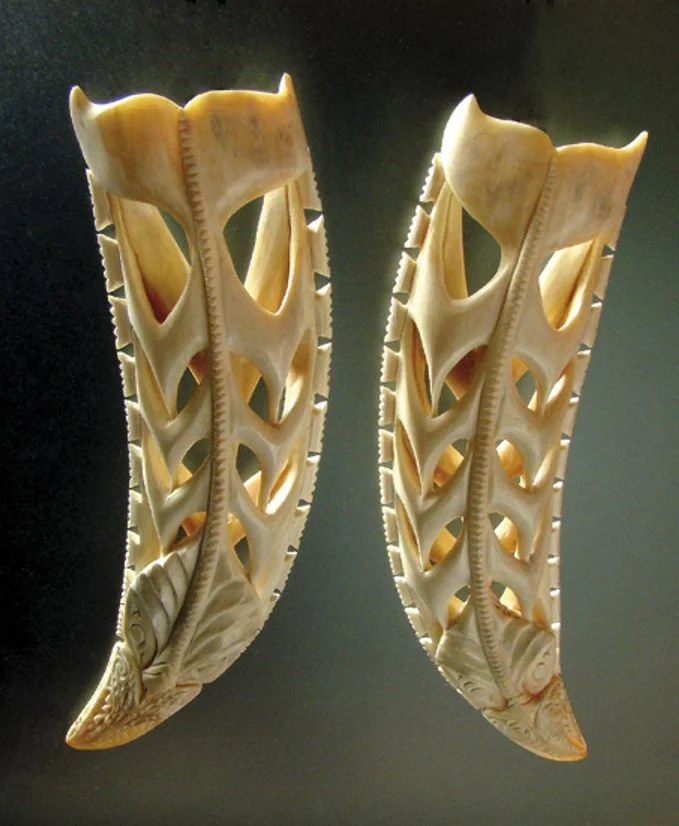 A pair of whale figures carved from a tooth of the whale called Hoon