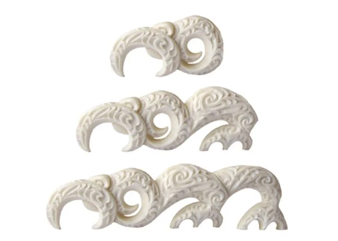 Manaia face representing a pāua (top), manaia face and limb representing a fish (centre), manaia face with two limbs representing a seal (bottom). Adapted from details of Sir Tīpene’s taonga kōrero.