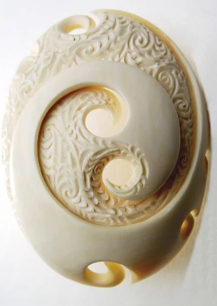 A carving from a sperm whale tooth representing ira, the dual complementary life force