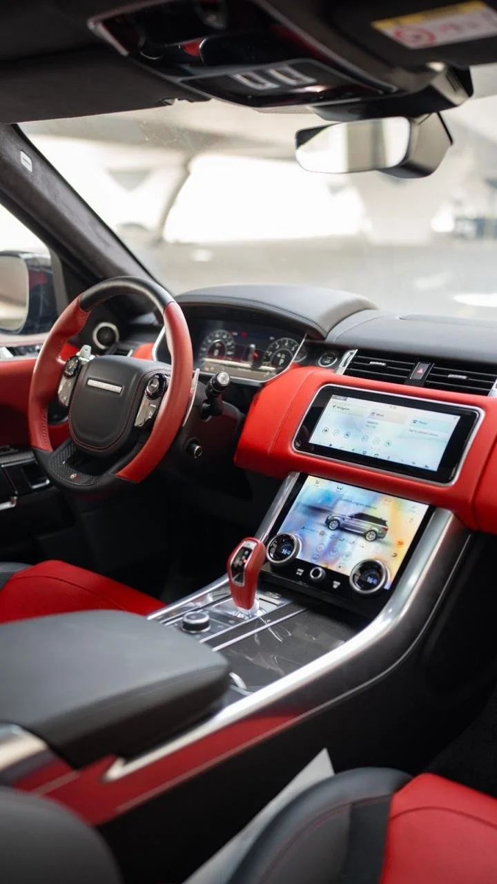 Range Rover Sport SVR red and black luxury interior with dual touchscreen dashboard – Dubai rental