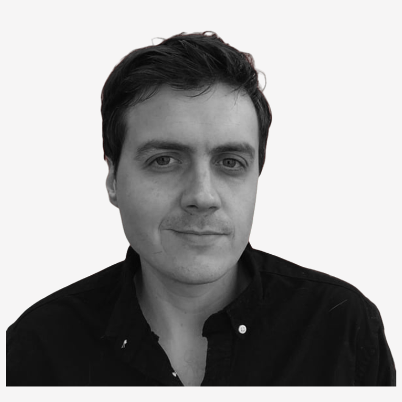 Black and white portrait of a man with dark hair wearing a dark collared shirt, facing slightly to the right.