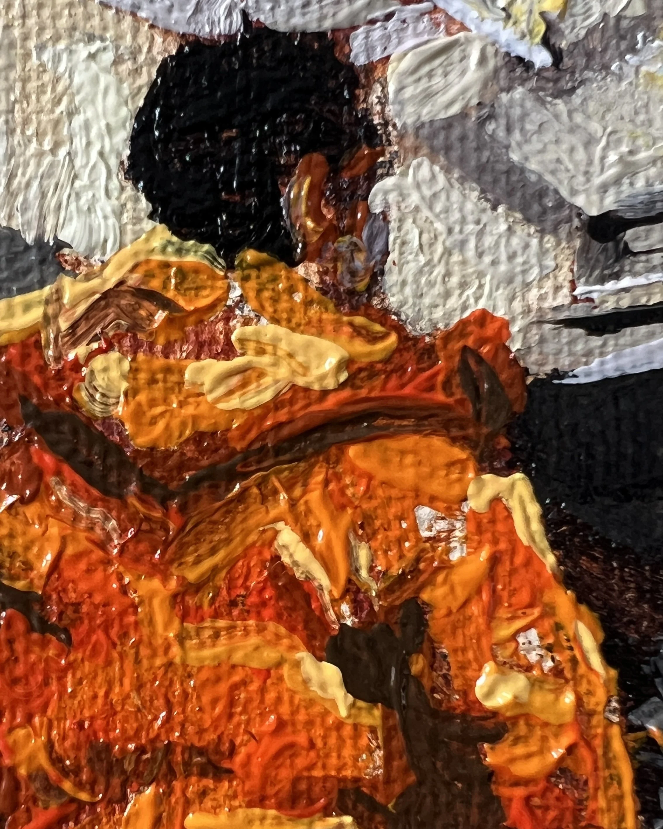 Close up detail of orange puffa jacket back and hood with some architectural details in the background.