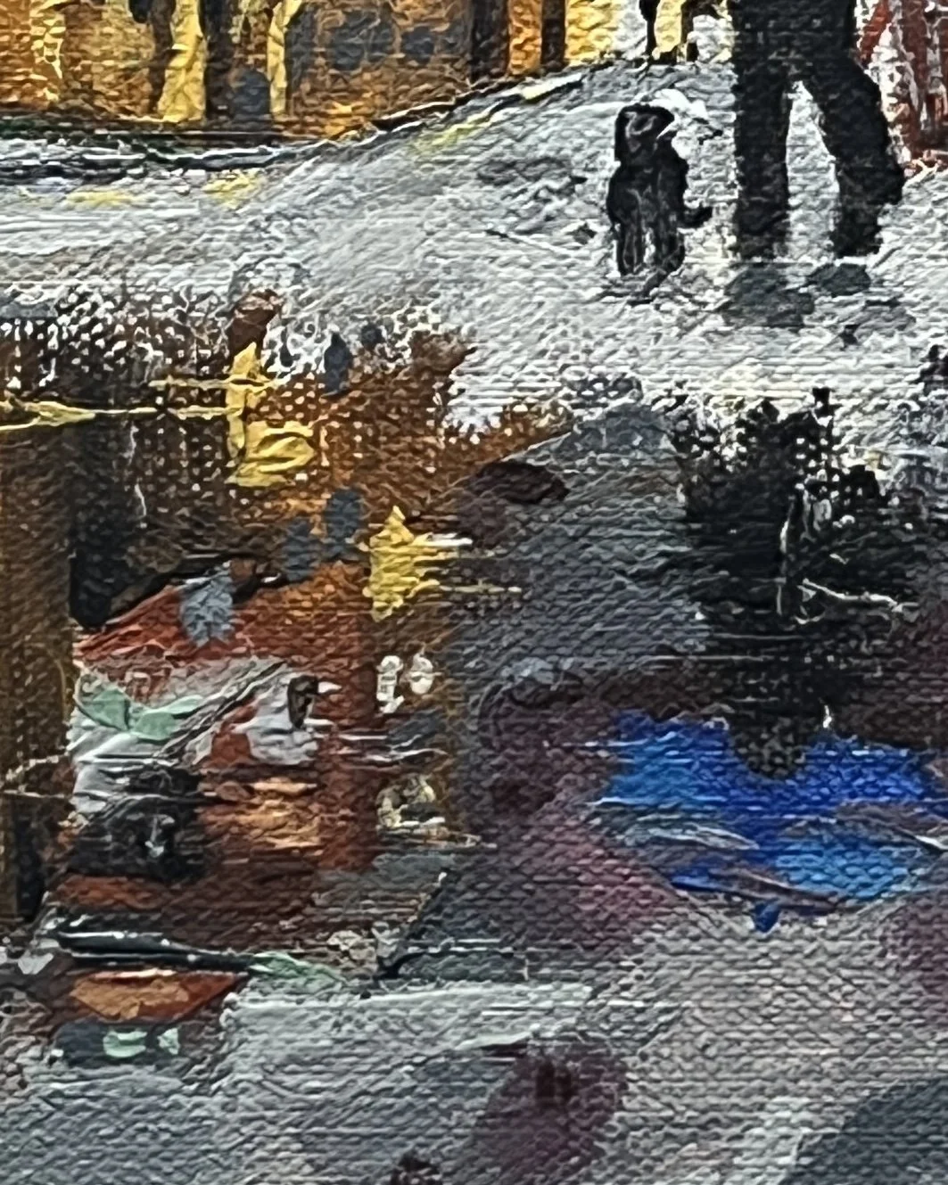 Close up detail of reflections in the puddle on Brewery Lane, Lancaster. The old brewery and a woman with a blue umbrella walking a dog are reflecting as rain spots are hitting the puddle.