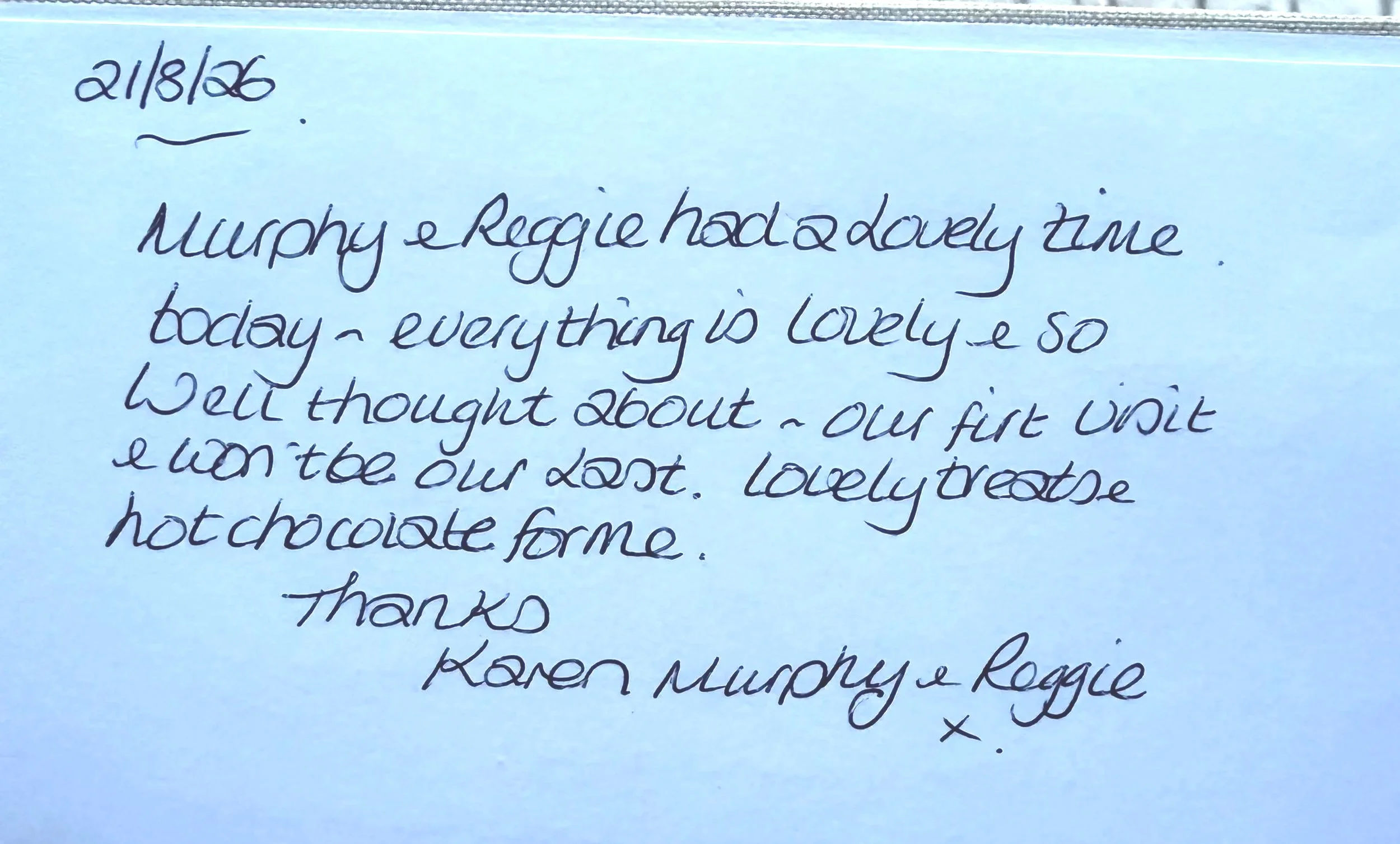 Handwritten note on blue paper dated 21/8/26, expressing love and appreciation for Murphy and Reggie, mentioning chocolate and a special time.