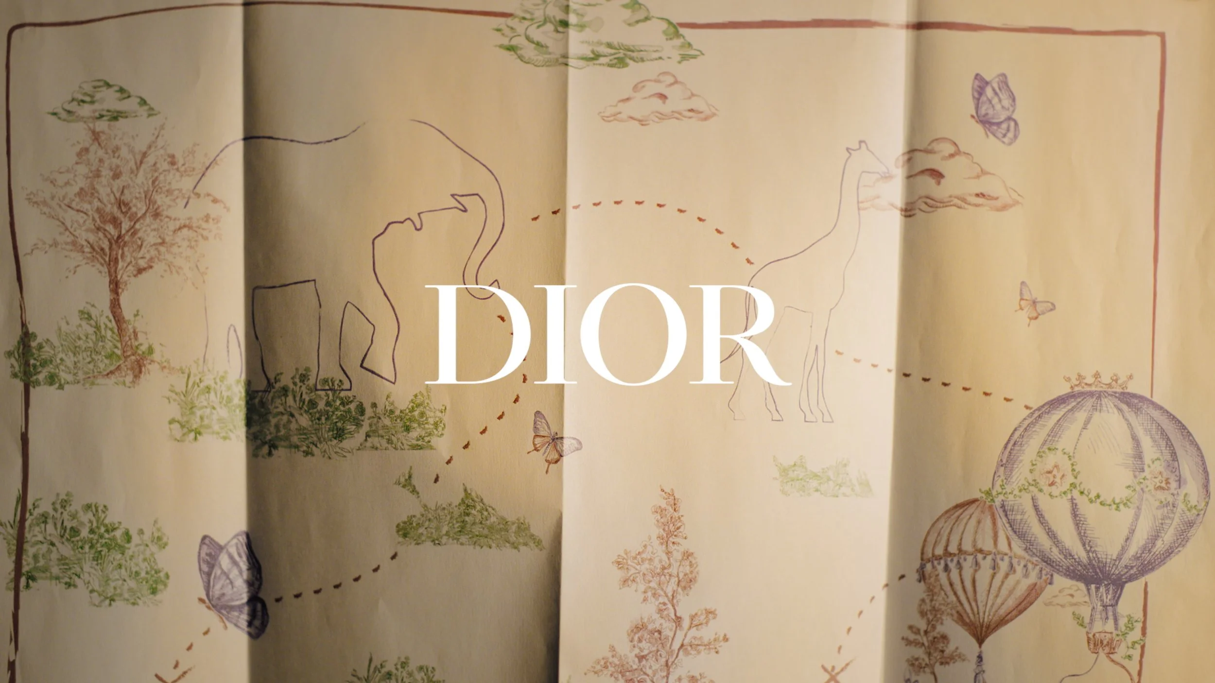 A whimsical drawing of a map with animals and nature scenes, featuring a zebra, butterflies, trees, clouds, hot air balloons, and the Dior logo overlayed on the image.