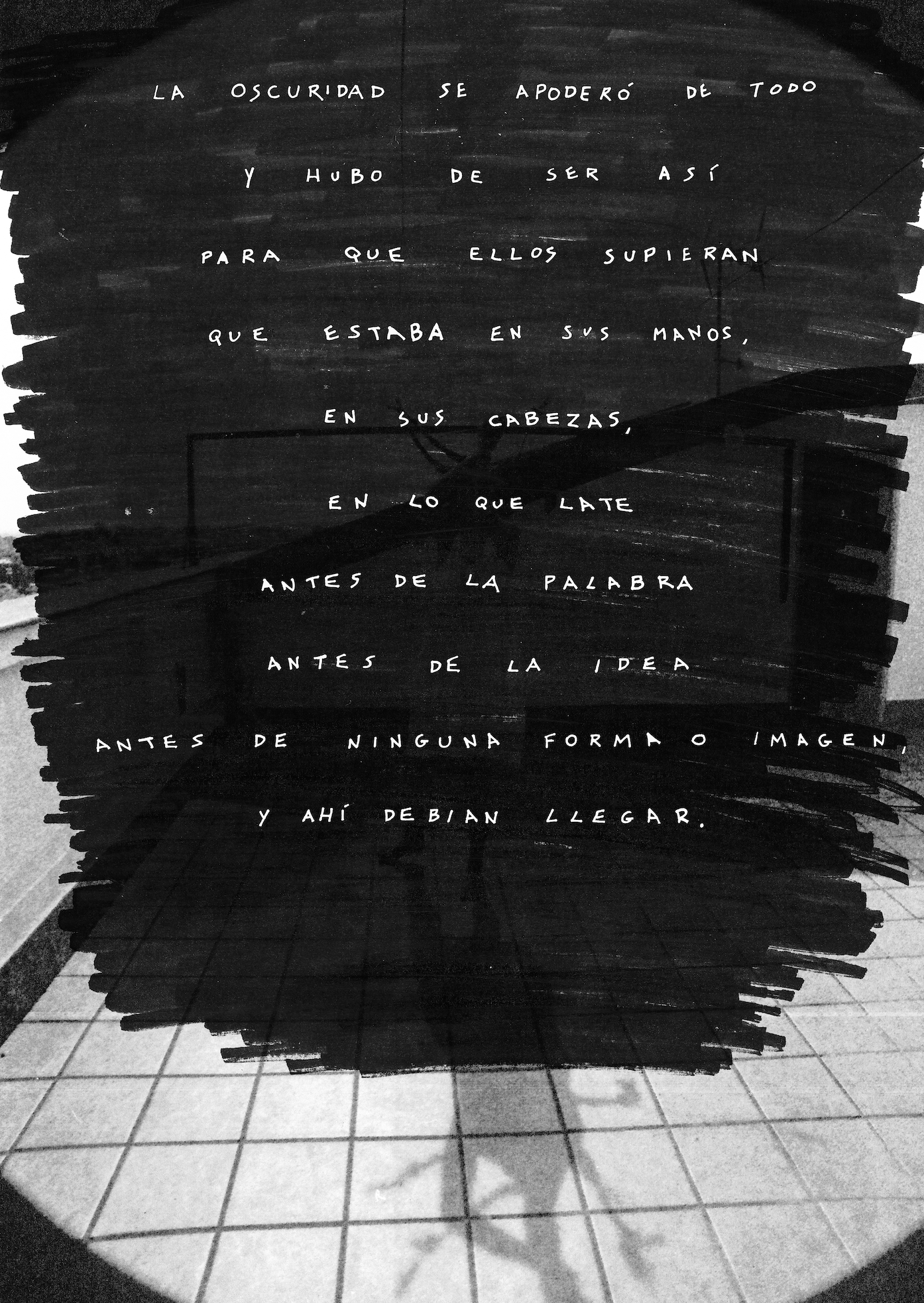 A blackboard with handwritten Spanish text in white chalk, positioned next to tiled flooring. The text discusses themes of darkness and arrival.