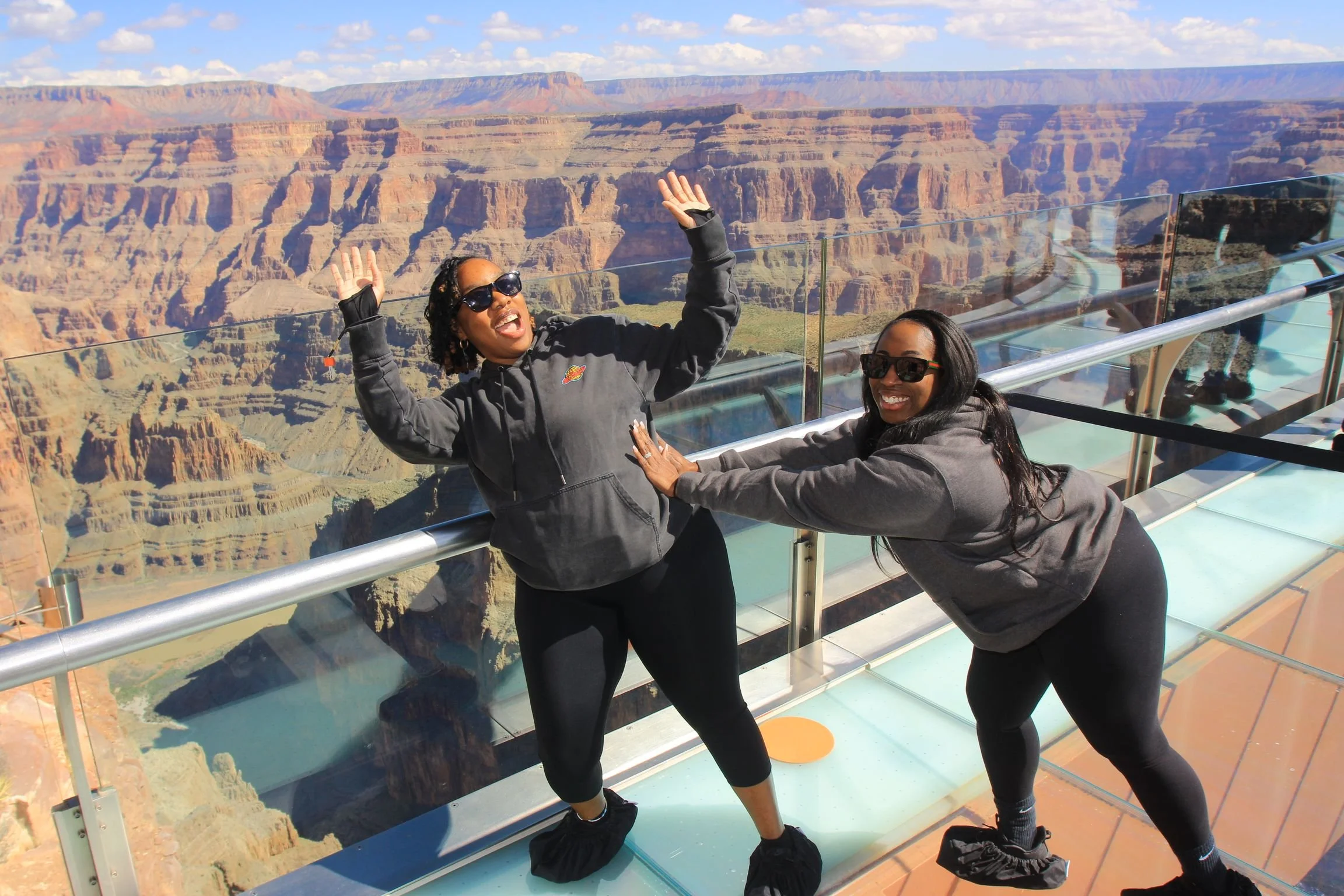 Two women having playful fun at the Grand Canyon West Rim.