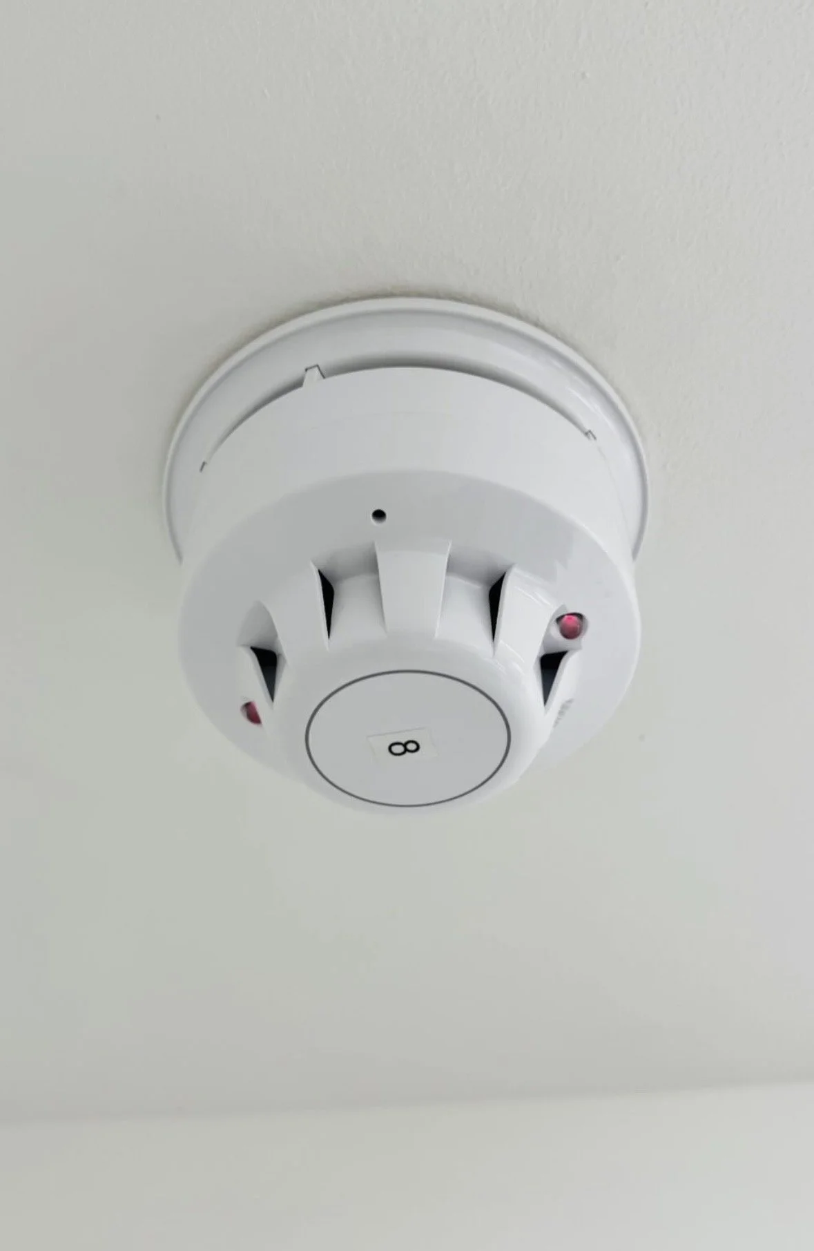 Fire alarm mounted on ceiling.
