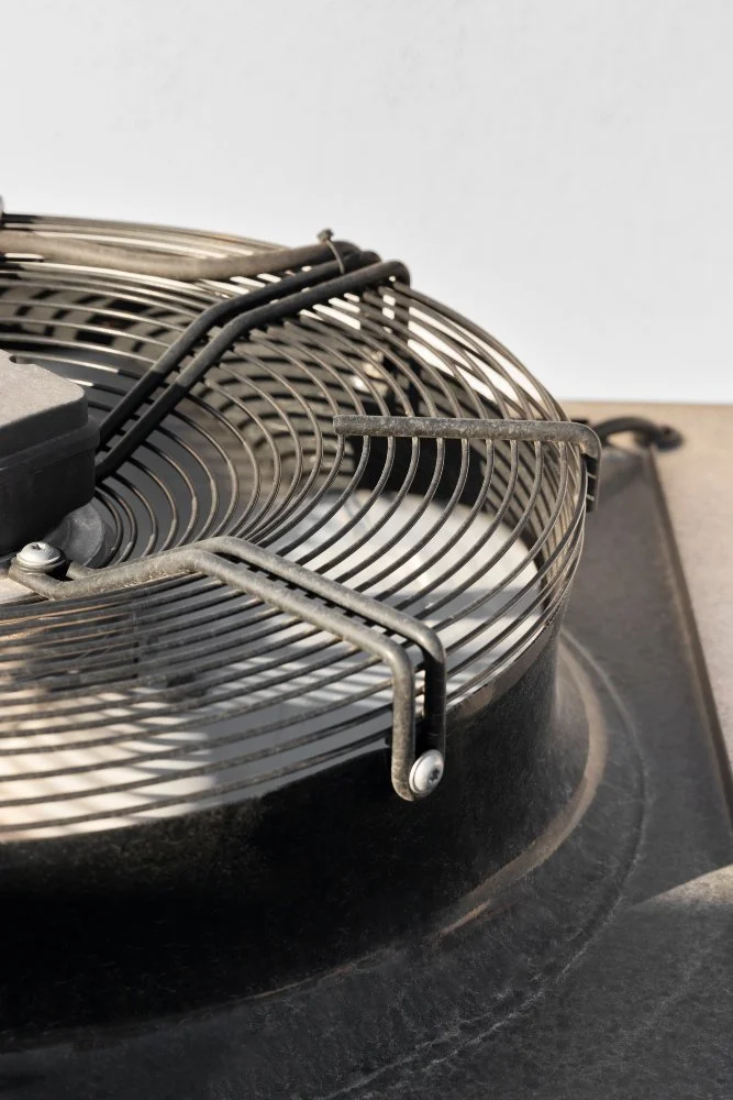 Close-up of a round metal grill with a stand, possibly a barbecue or outdoor grill surface.