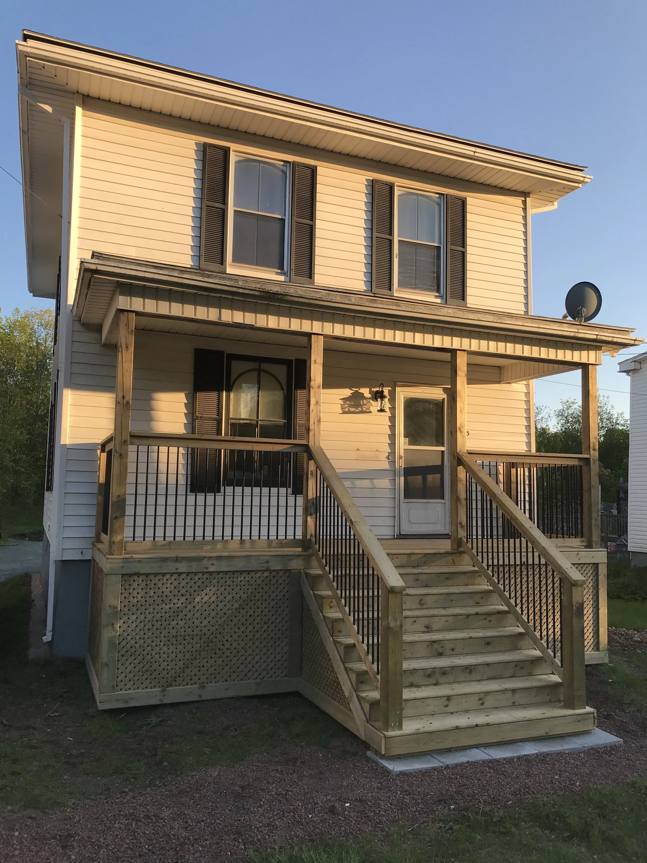 Two-storey house with a new front porch under construction.