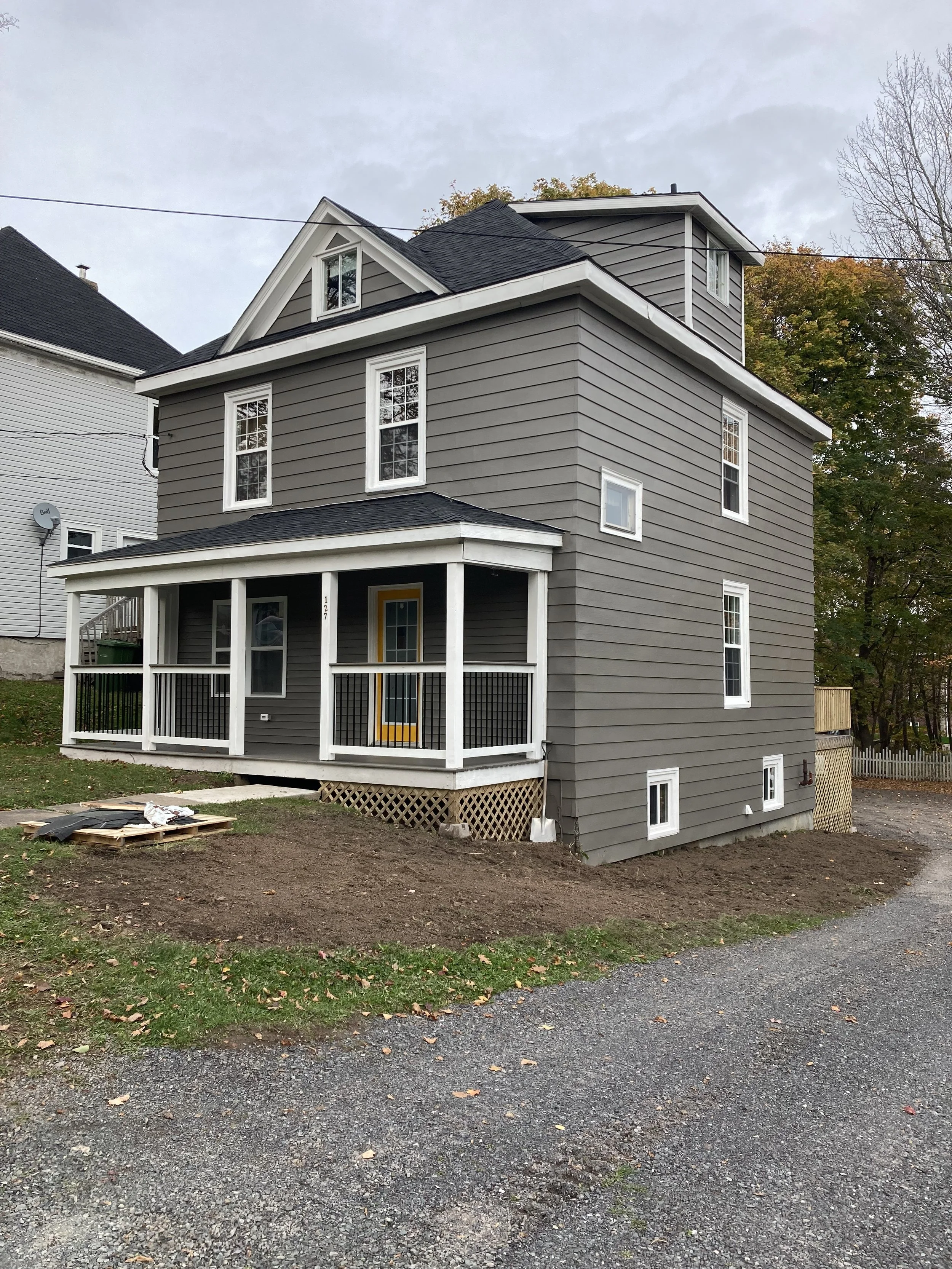 Renovated grey house with a covered front porch in Stellarton, Nova Scotia.