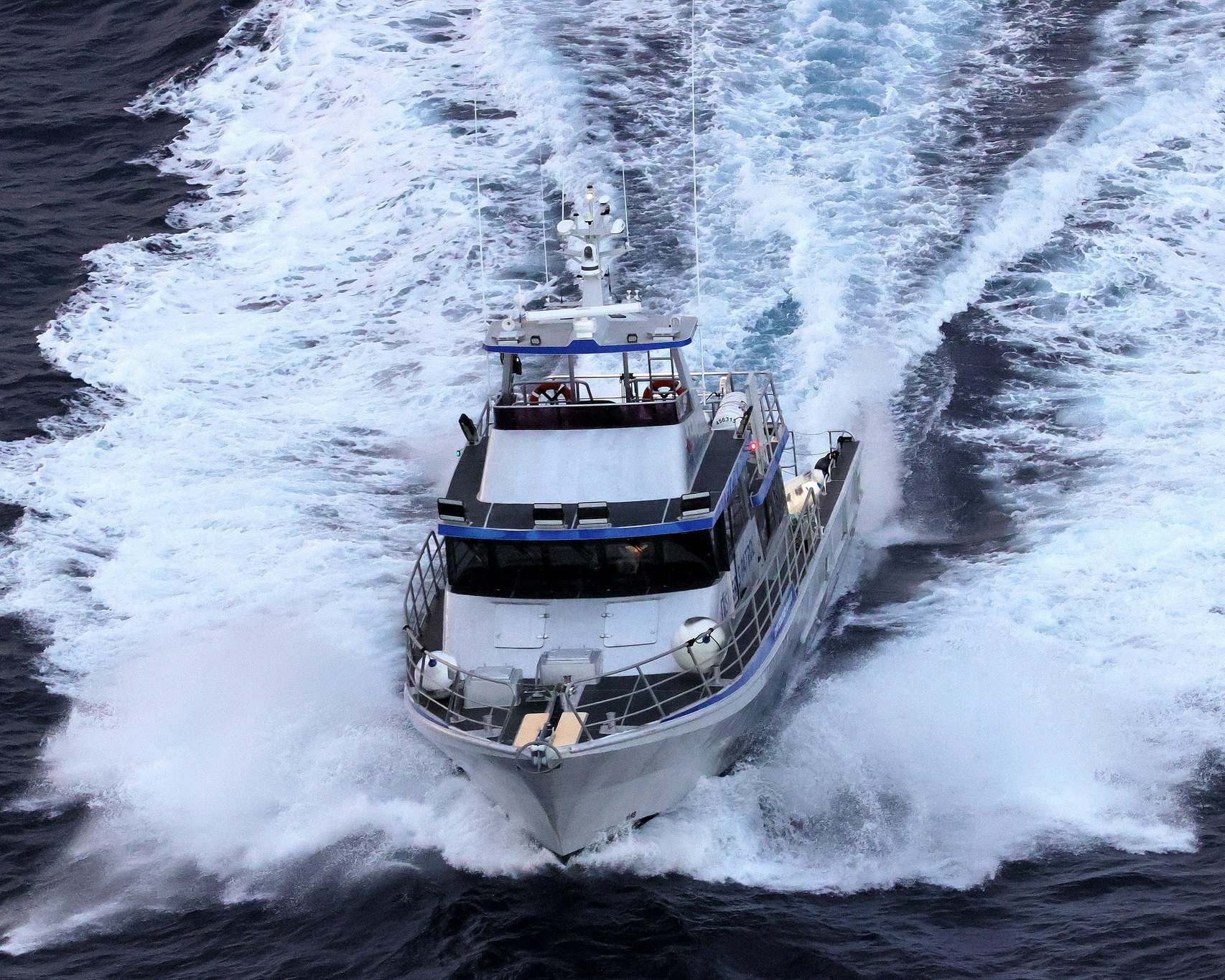 20m fisheries patrol vessel at speed, aerial view from ahead.
