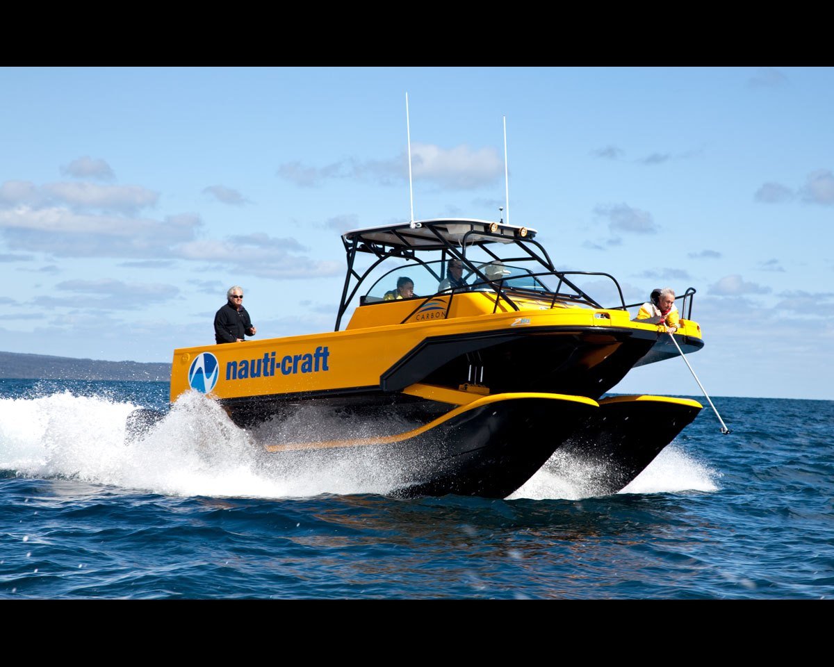 8m R&amp;D catamaran 2-Play at speed, bow quarter view.