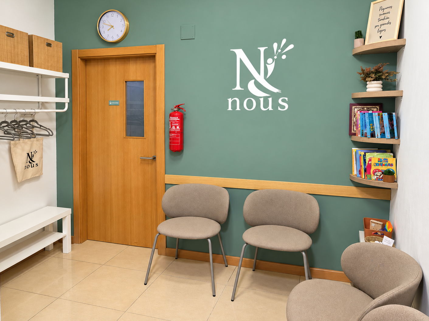 Sala de espera con sillas beige, muro verde con logo 'N & Nous', estanterías con libros y decoración, reloj en la pared y extintor de incendio.