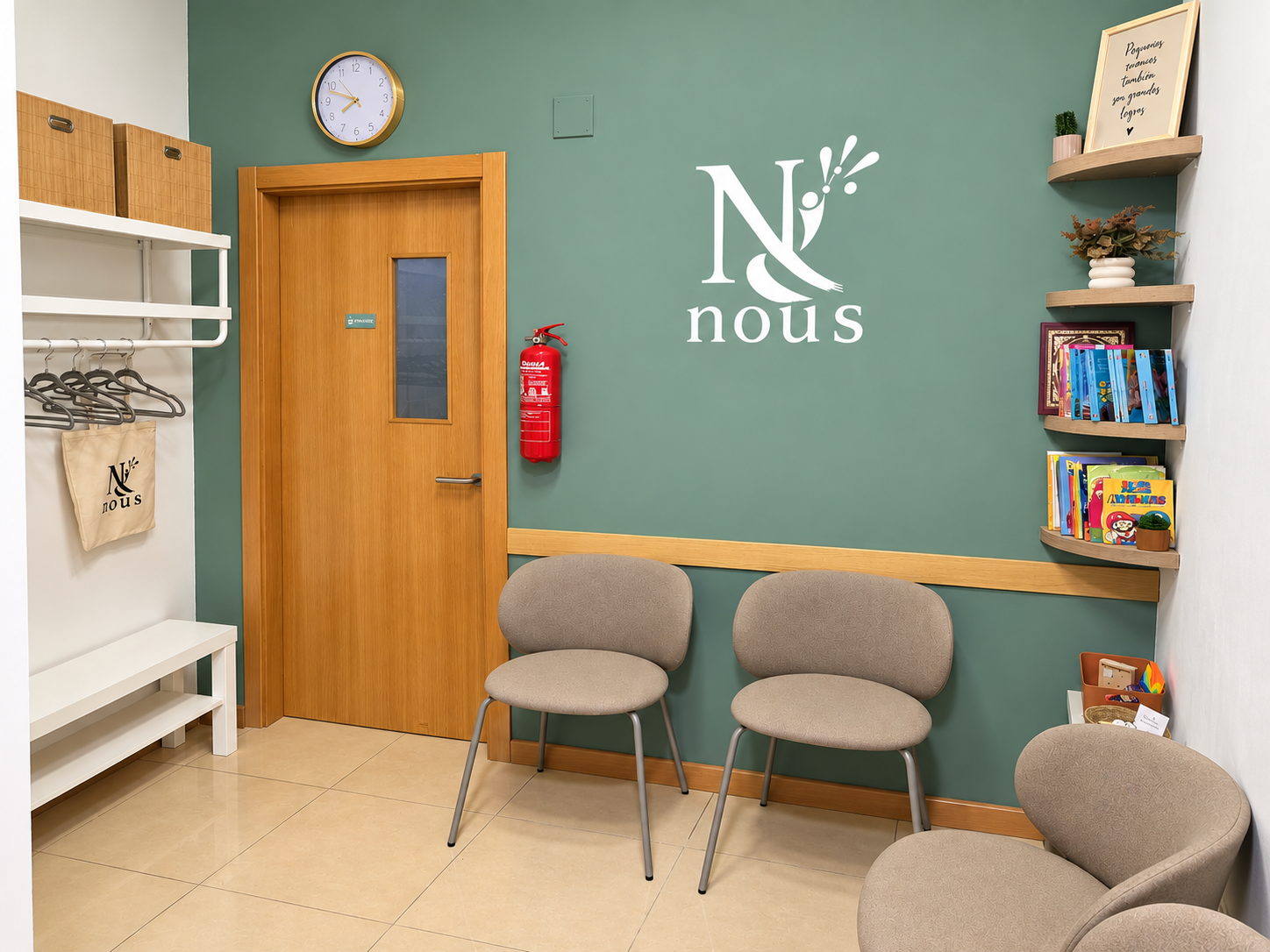Sala de espera con tres sillones beige, una pared verde con el logo 'N ous', estantes con libros y plantas, reloj en la pared y extintor de incendios junto a la puerta de madera.