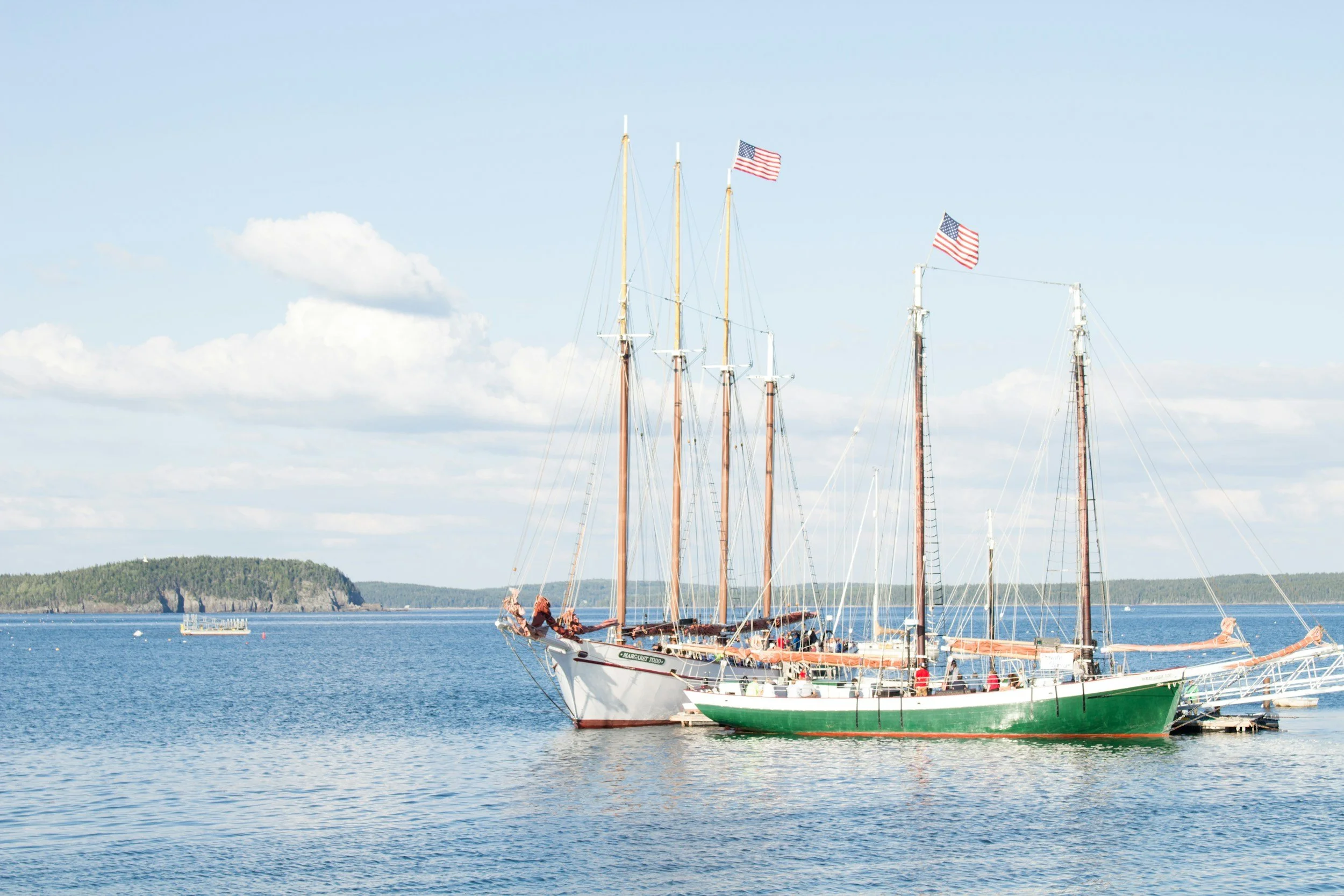 A peaceful sailboat rests at a marina, calm water, and a tree-lined shoreline beneath a partly cloudy sky. The scene evokes the healing power of art therapy, creating space for reflection, self-expression, mindfulness, and growth.