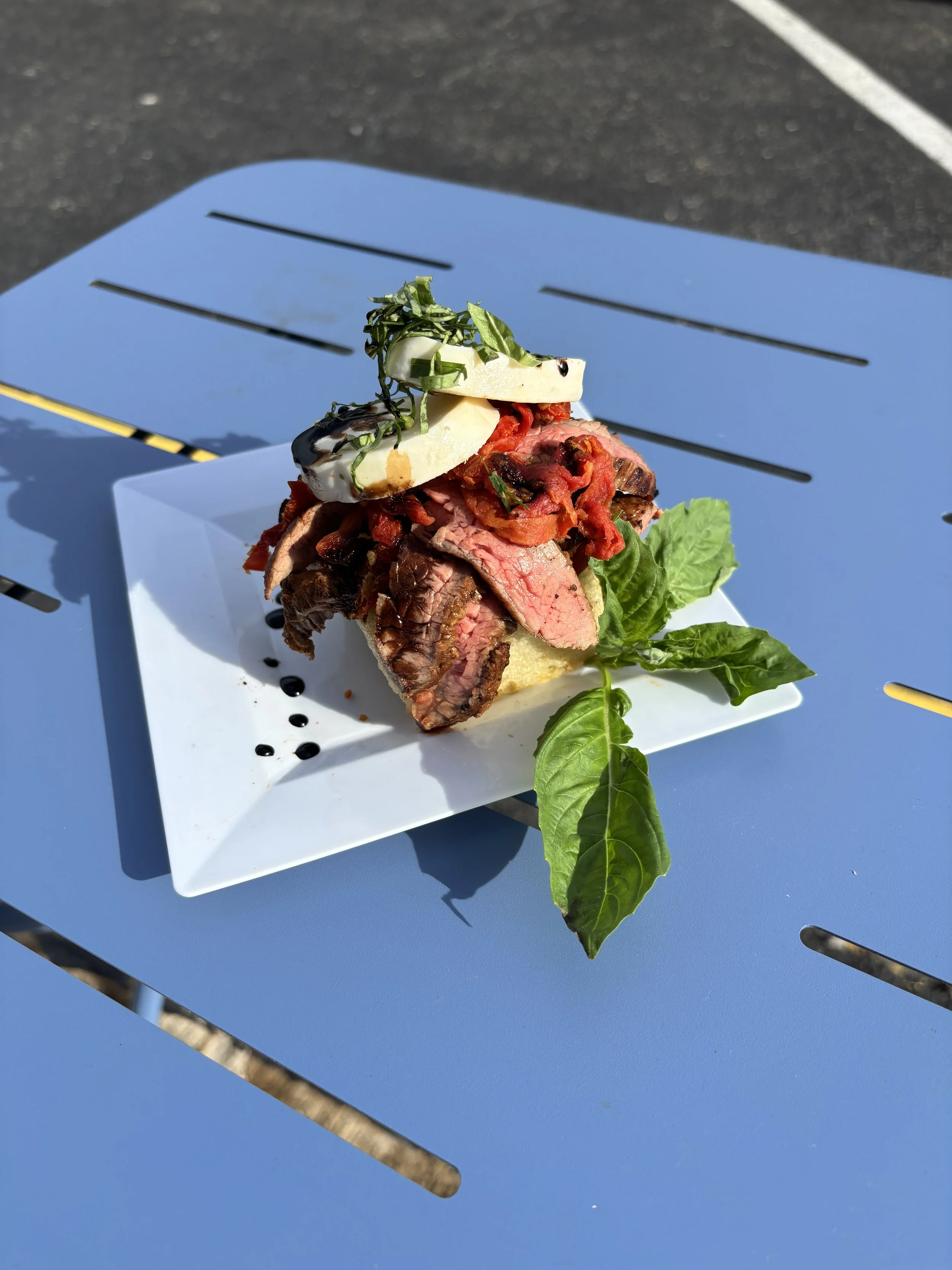 Sourdough focaccia topped with marinated and grilled steak, fresh mozzarella and classic bruschetta mix and basil