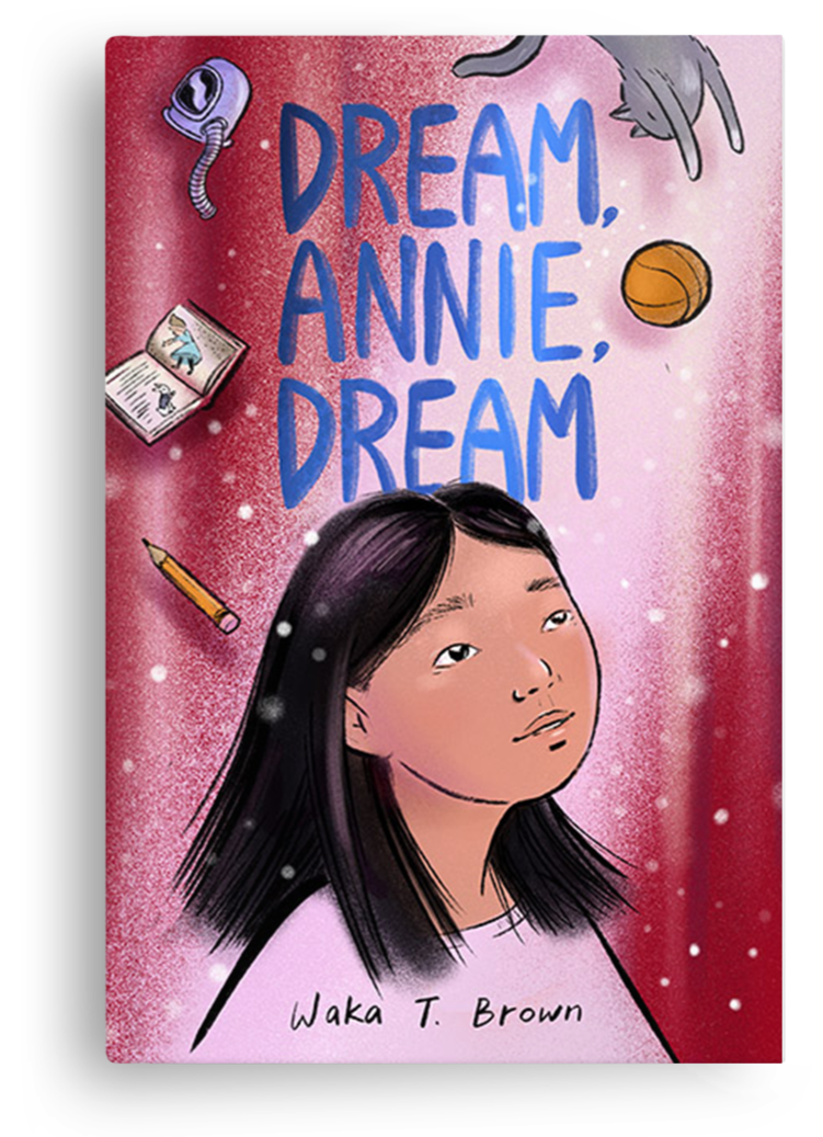 Book cover titled "Dream, Annie, Dream" by Waka T. Brown, featuring a young girl with long black hair gazing upward, surrounded by illustrations of a book, a pencil, a basketball, a hairdryer, and a cat playing with a ball of yarn, on a pink and red background.