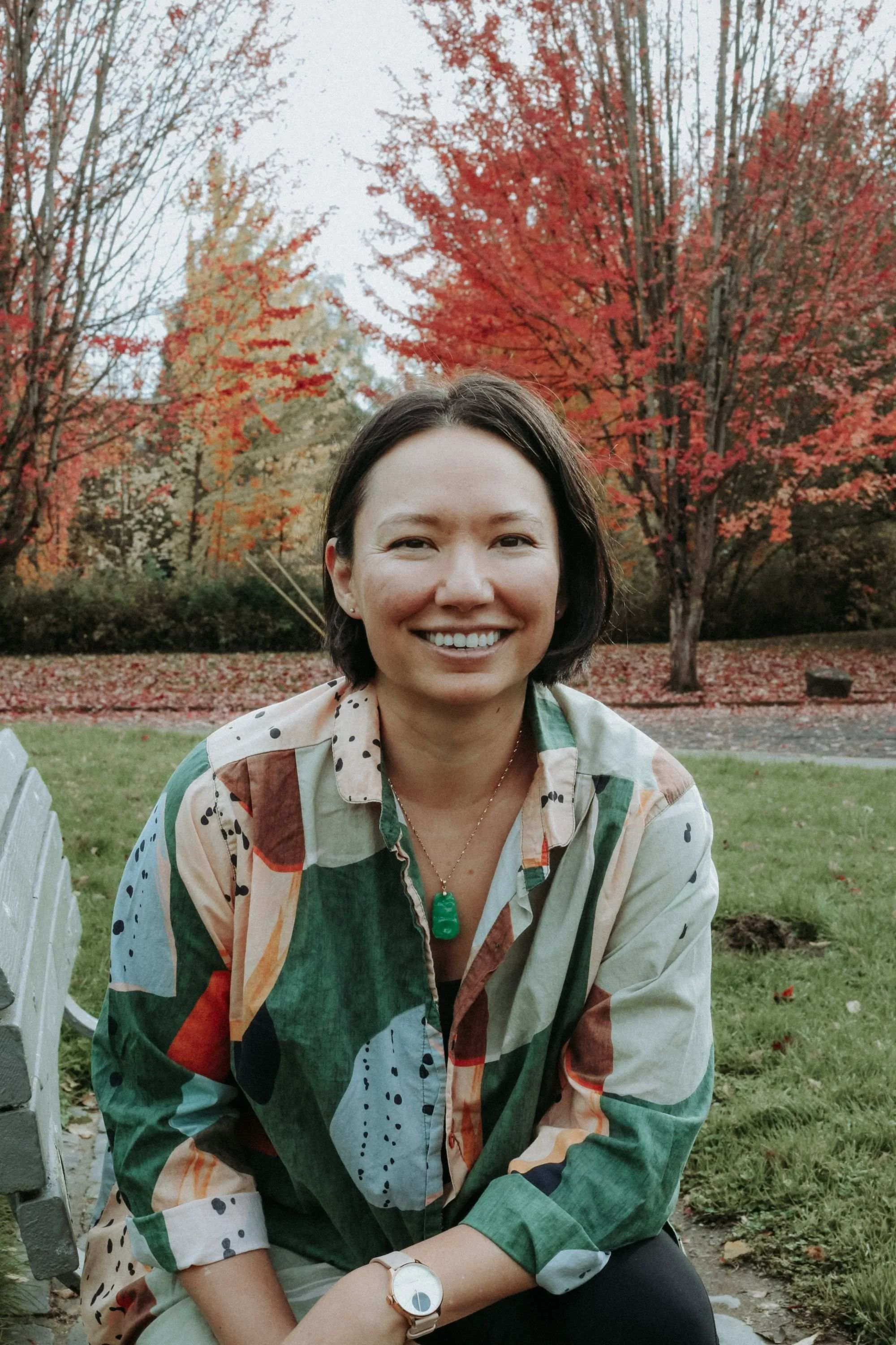 Author and illustrator Tracy Subisak smiling outdoors in front of autumn trees.