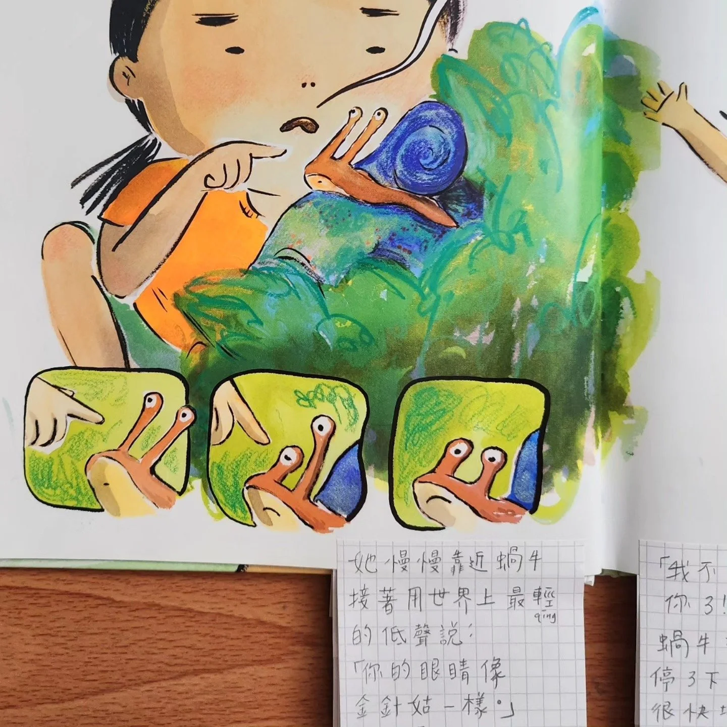 A colorful illustration of a girl with black hair, orange shirt, and beige skin, pointing at a snail on her finger. The snail has a blue shell and an orange body. Several small illustrations show the girl’s finger with a snail, with some pointing and others relaxed. Handwritten notes in Chinese characters are at the bottom.