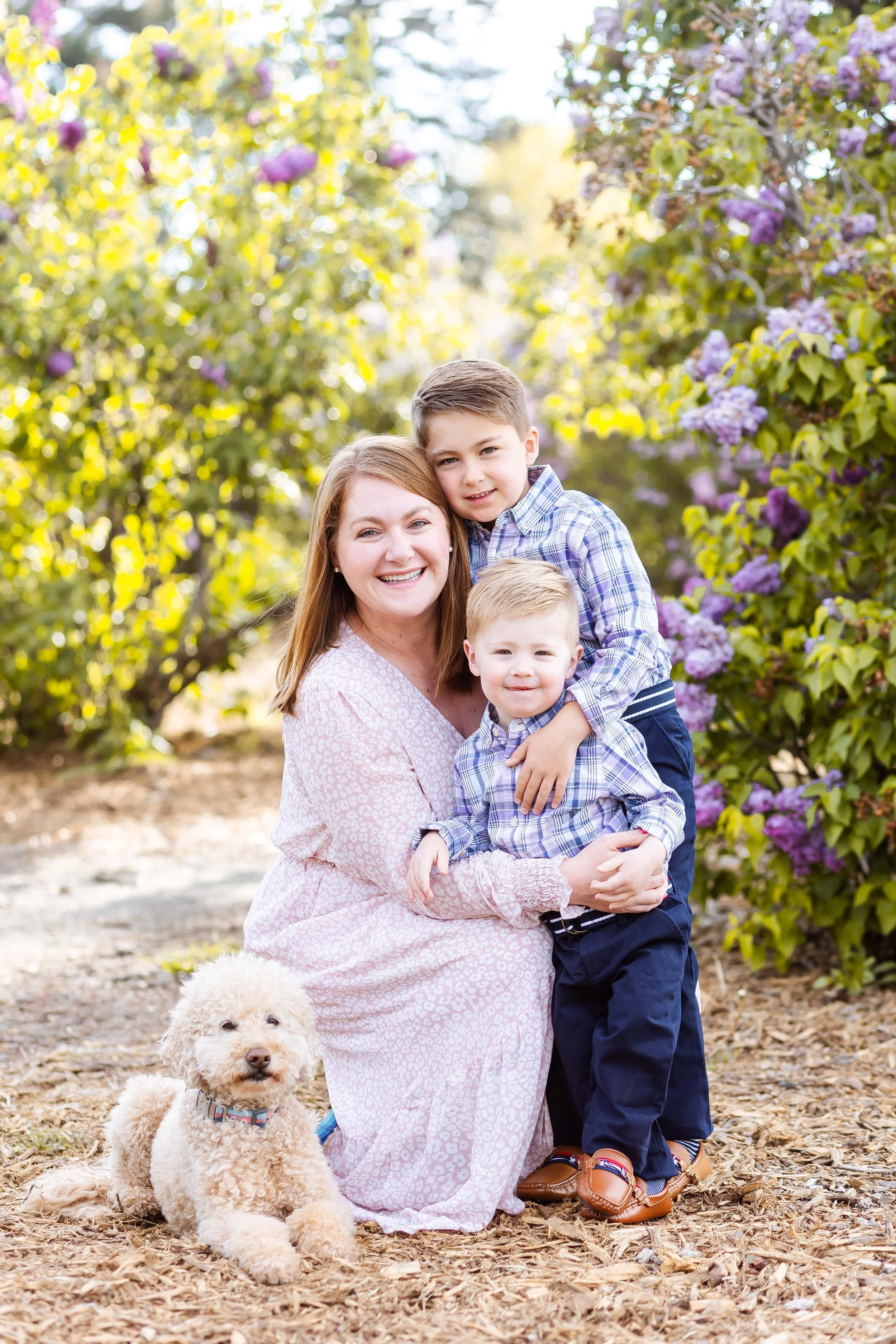 A smiling woman with two young boy posing outdoors at a family session with East and Elm Portrait studio in Rochester, NY.