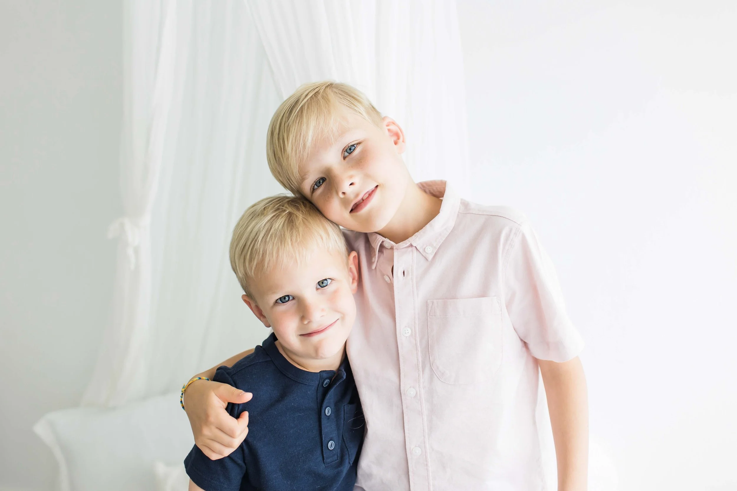Two young brothers hugging and smiling in a Rochester NY sibling photography session