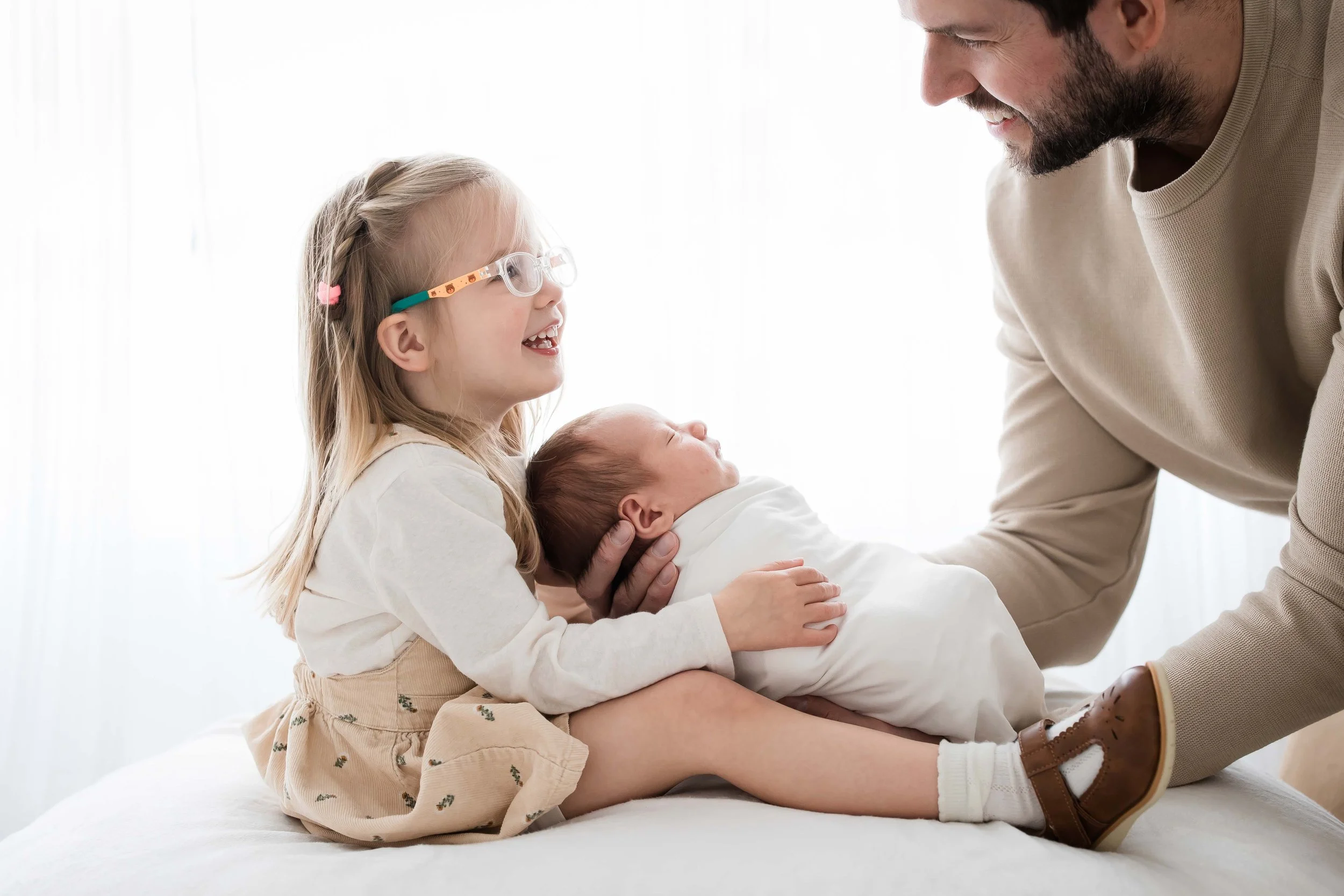 Fairport NY family photographer, father laughing with daughter and newborn during session