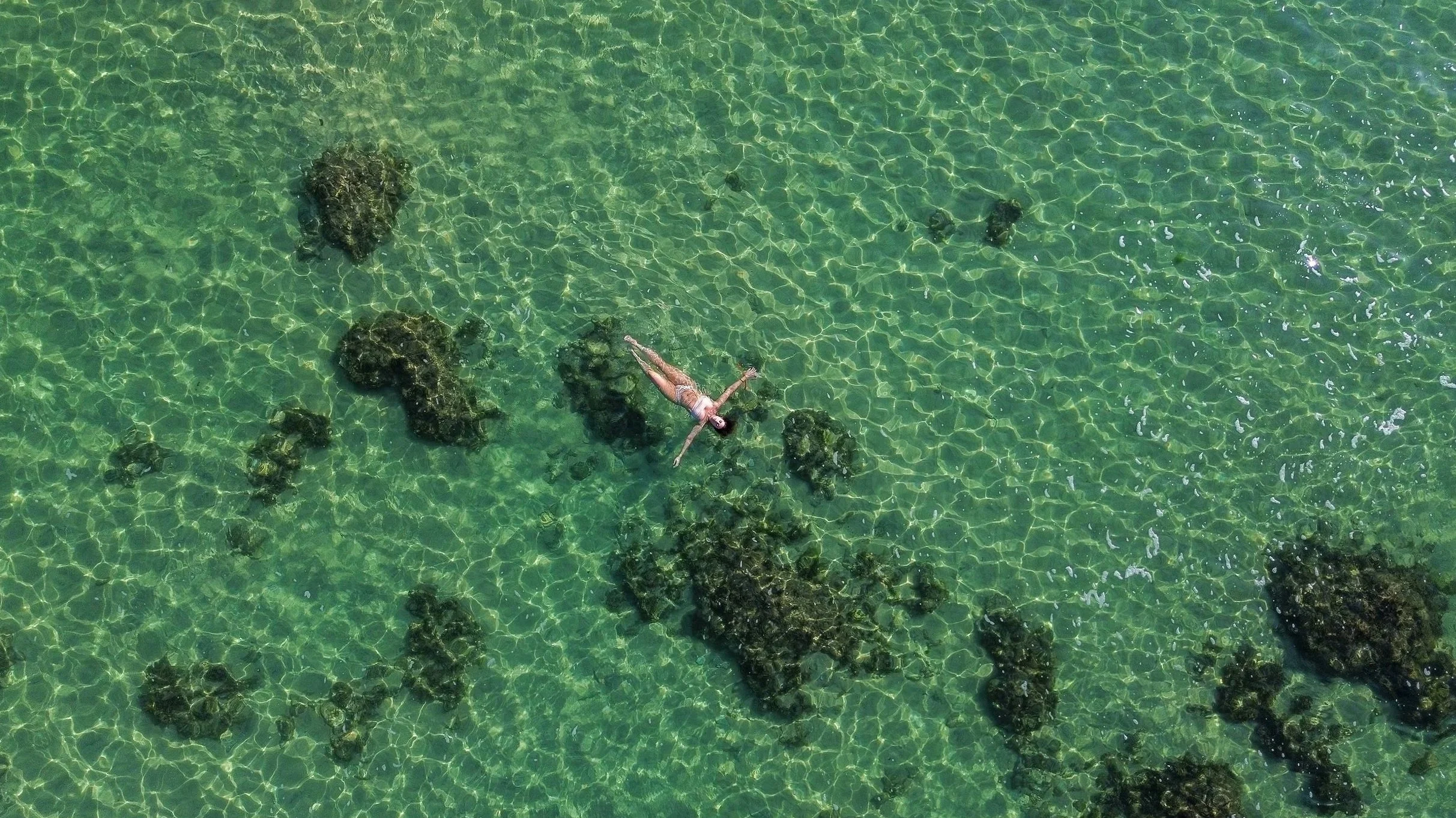 Woman floating in the blue ocean