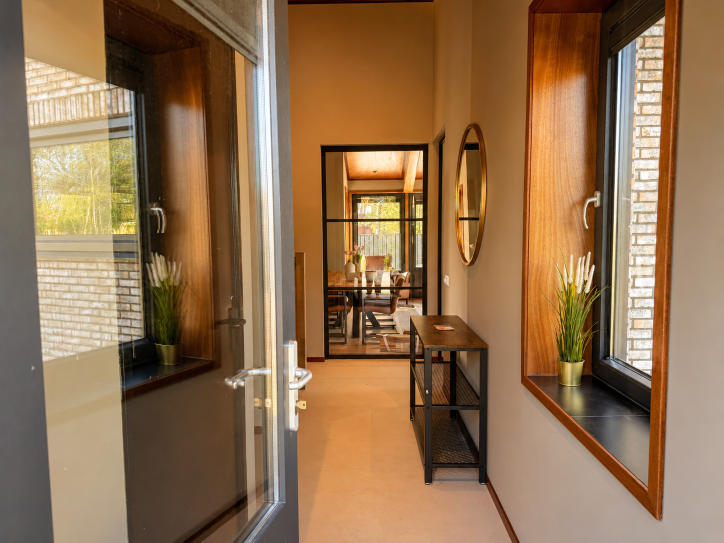 Hal met spiegel en doorkijk naar de woonkamer in Villa Oostermeer in Ballum op Ameland