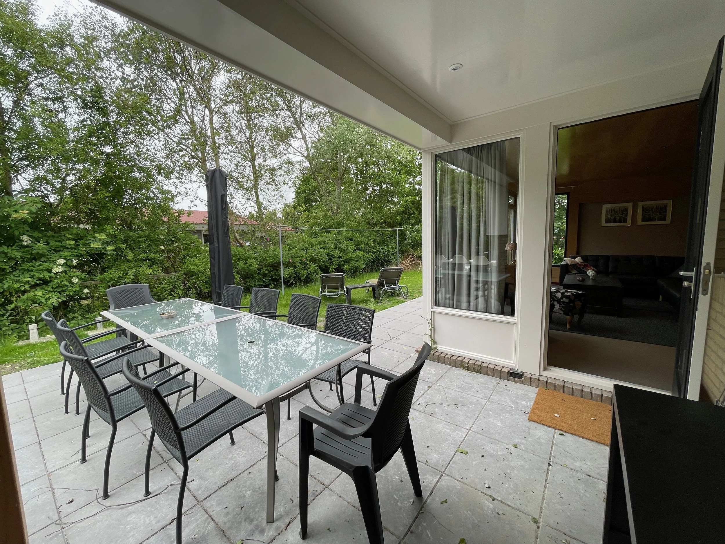 Overdekt terras met lange eettafel bij Bungalow Luitekamp in Ballum op Ameland