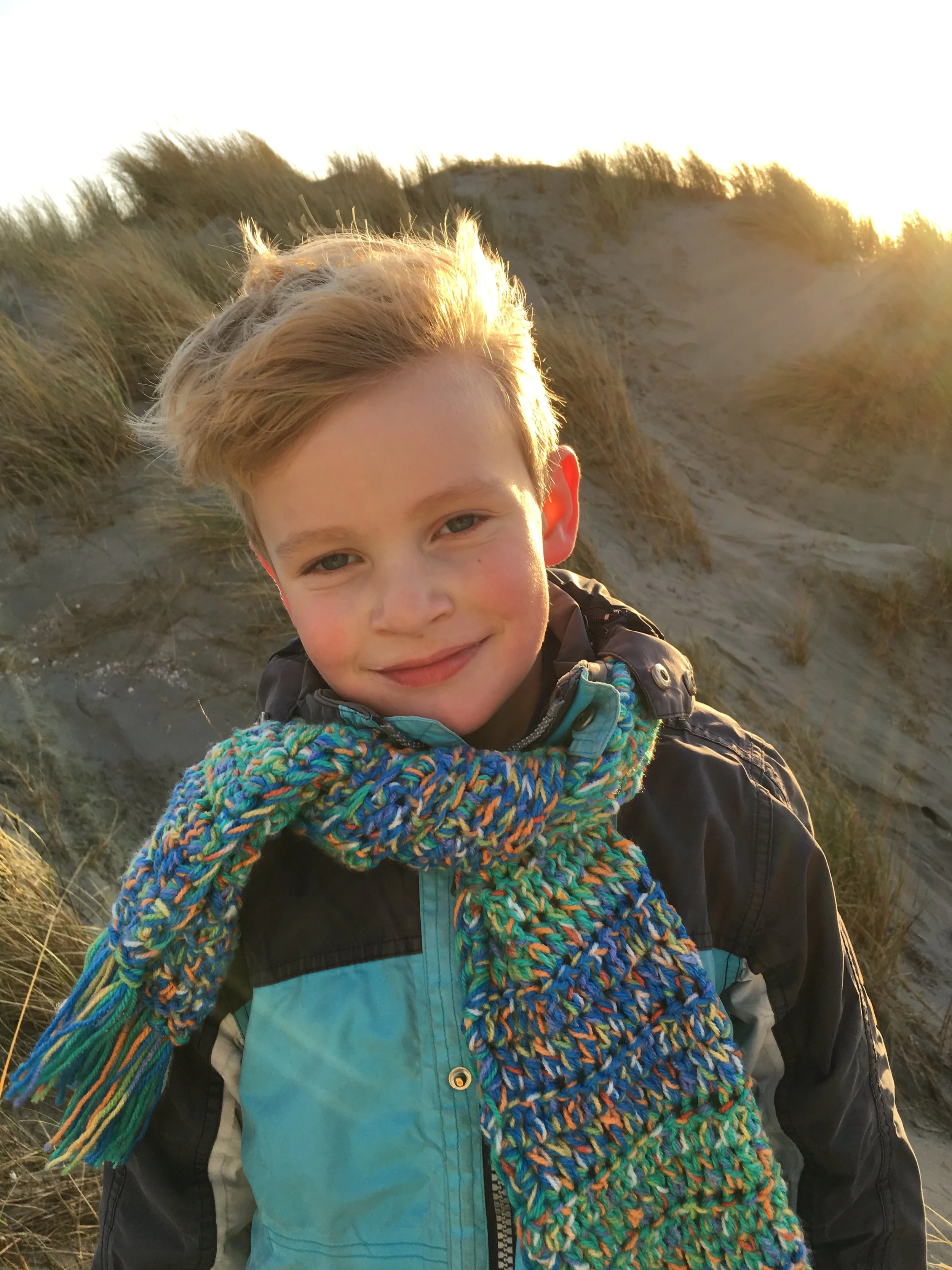 Lachend kind in de duinen bij ondergaande zon op Ameland