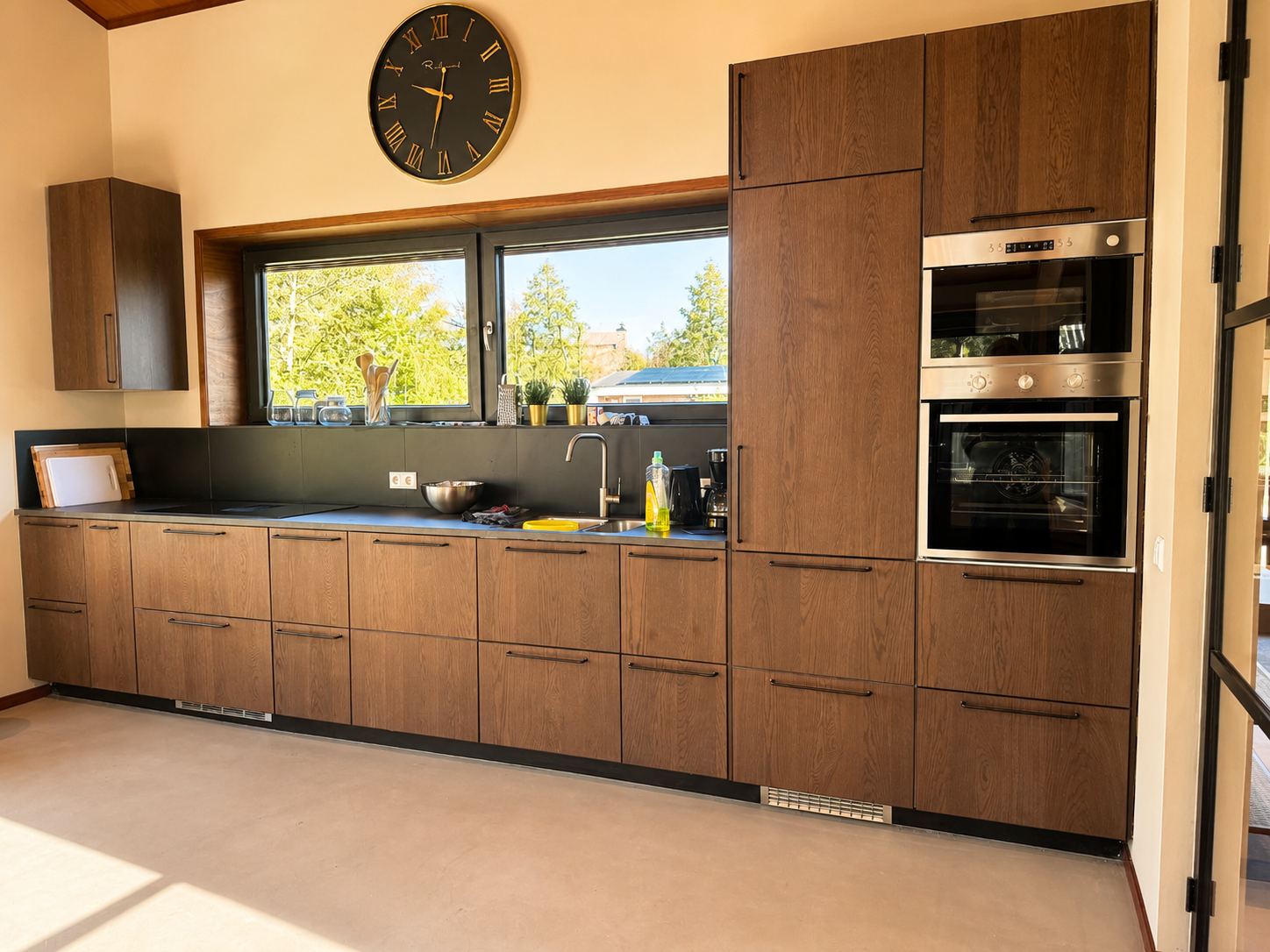 Keuken met houten kastenwand en twee ovens in Villa Duikenburg in Ballum op Ameland