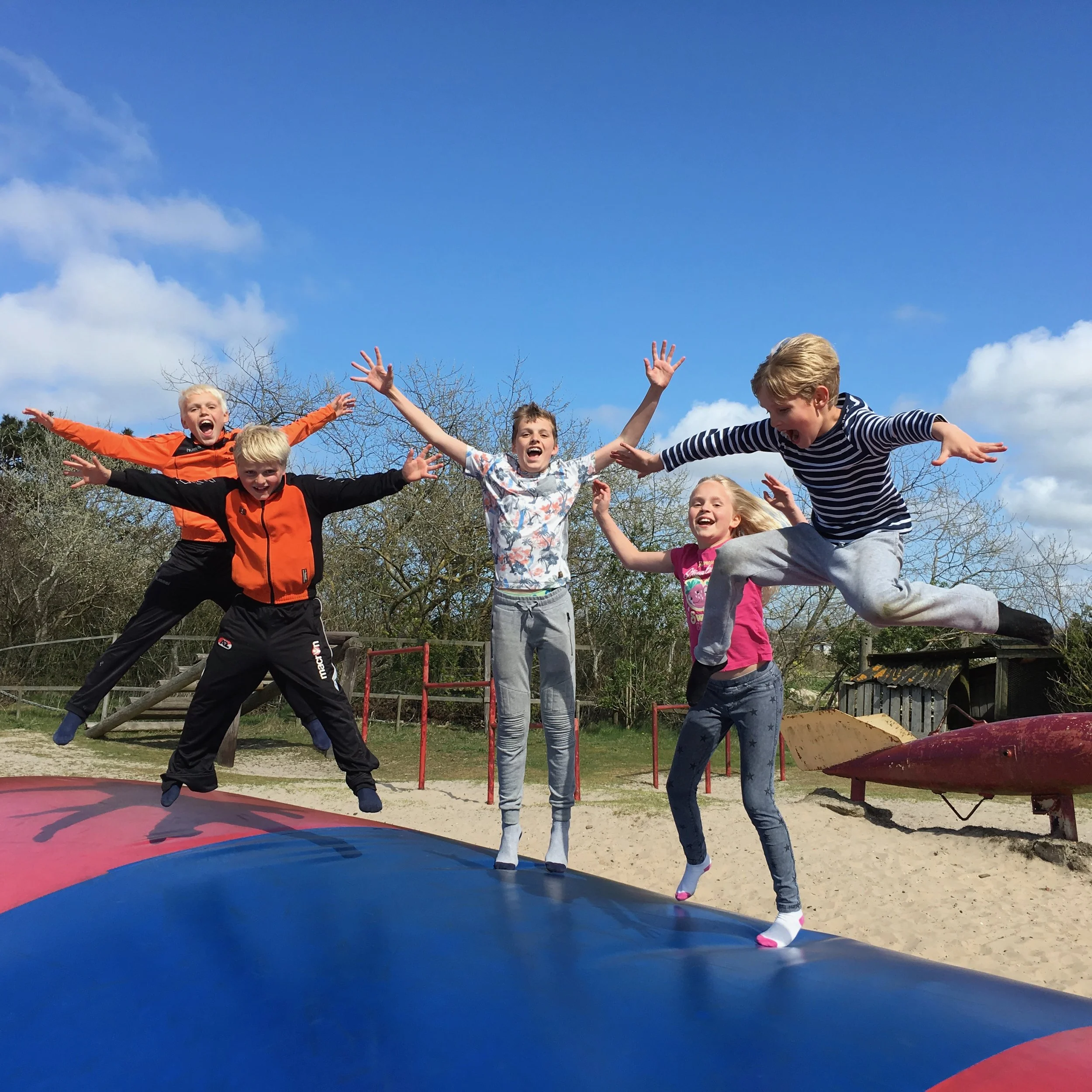 Vijf kinderen springen op het luchtkussen bij de speeltuin in Ballum op Ameland