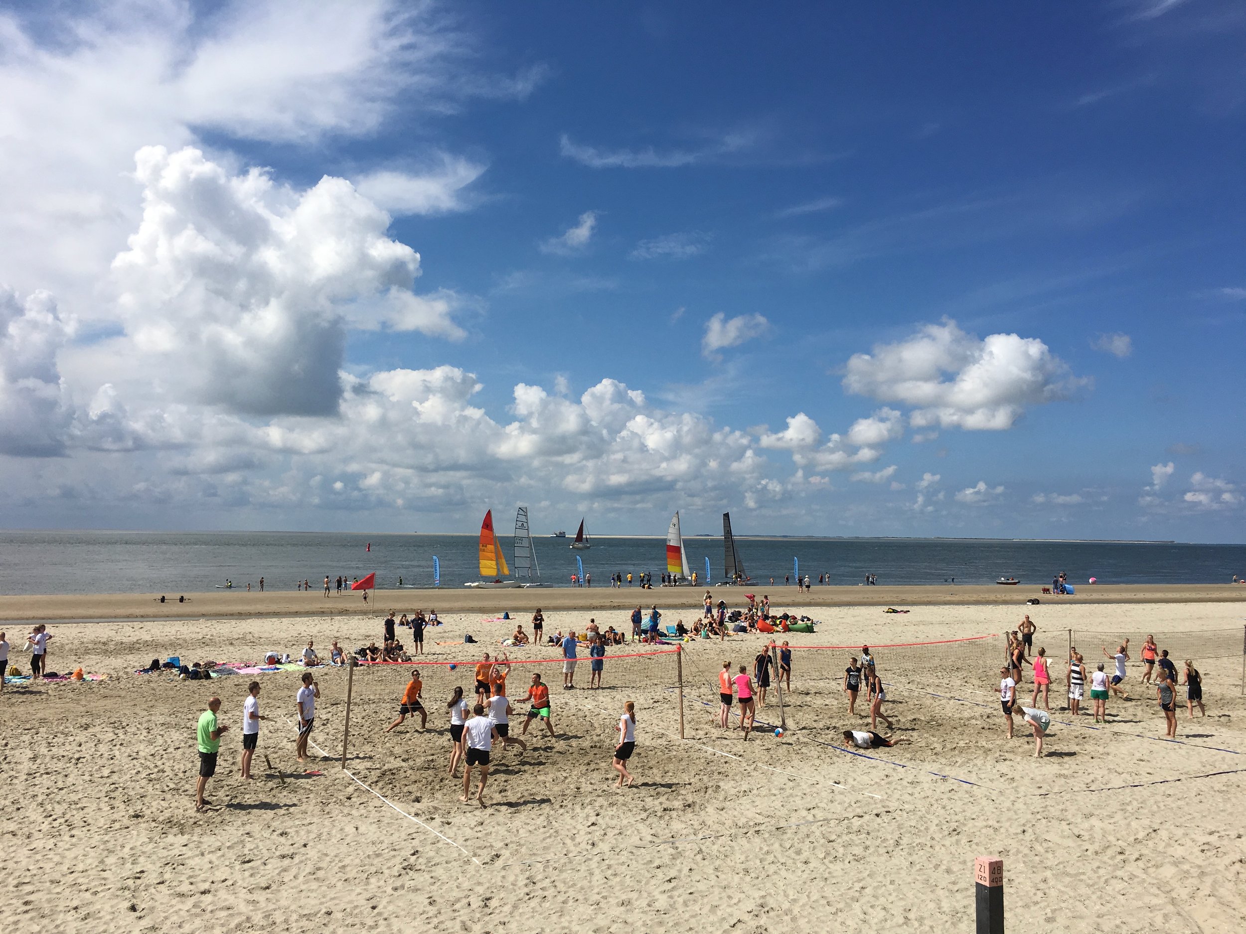 Druk strand van Ameland met strandvlaggen tijdens een evenement