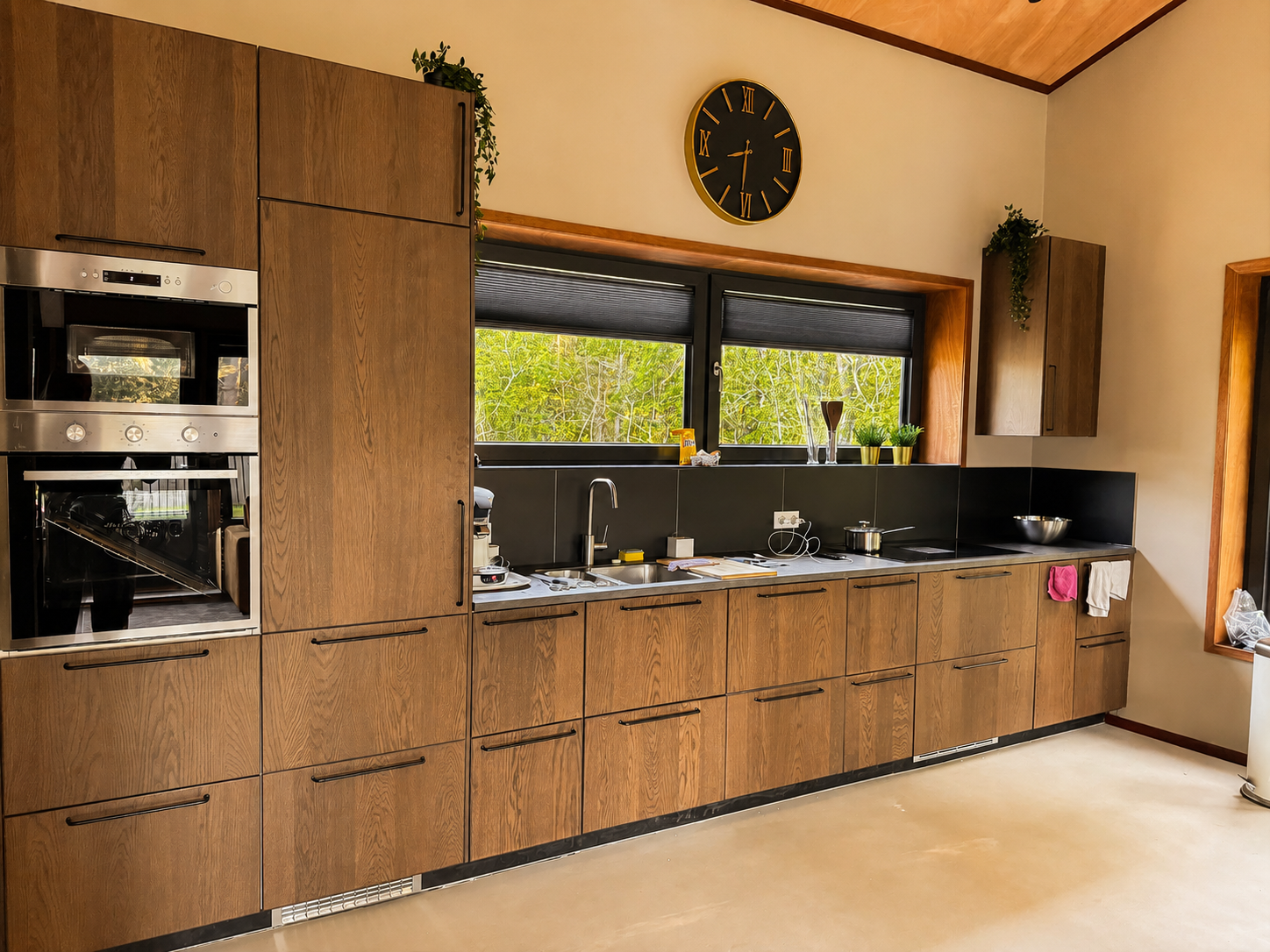 Keuken met houten kasten en inbouwovens in Villa Oostermeer in Ballum op Ameland