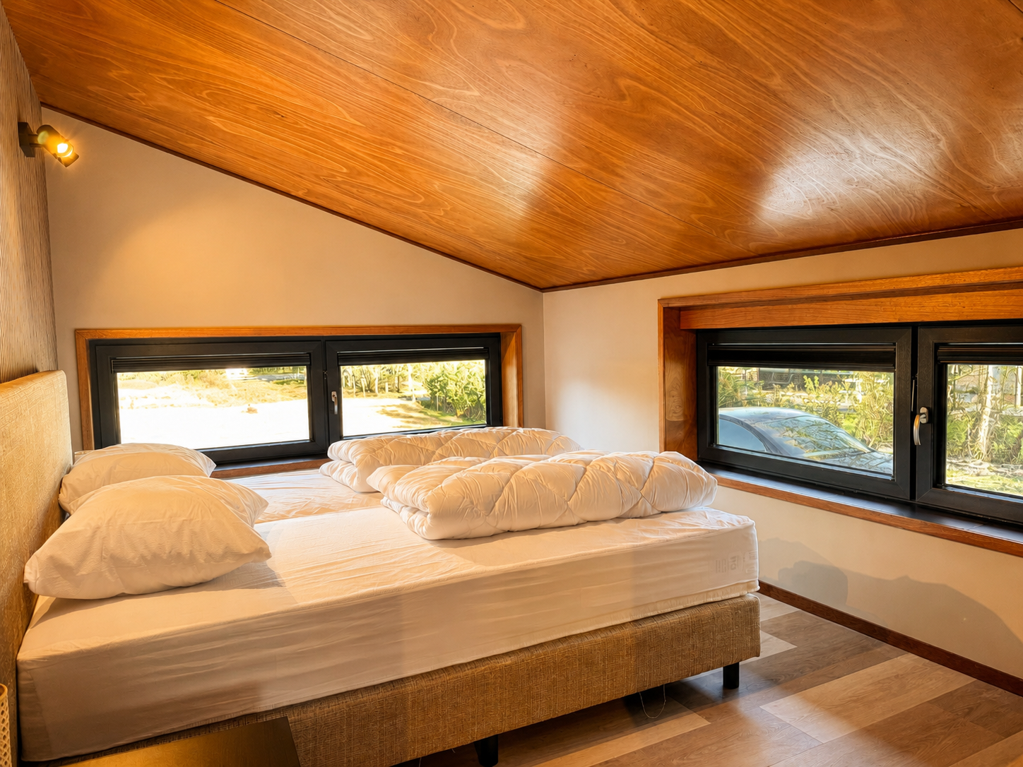 Slaapkamer boven met tweepersoonsbed en uitzicht op het bos in Villa Oostermeer in Ballum op Ameland
